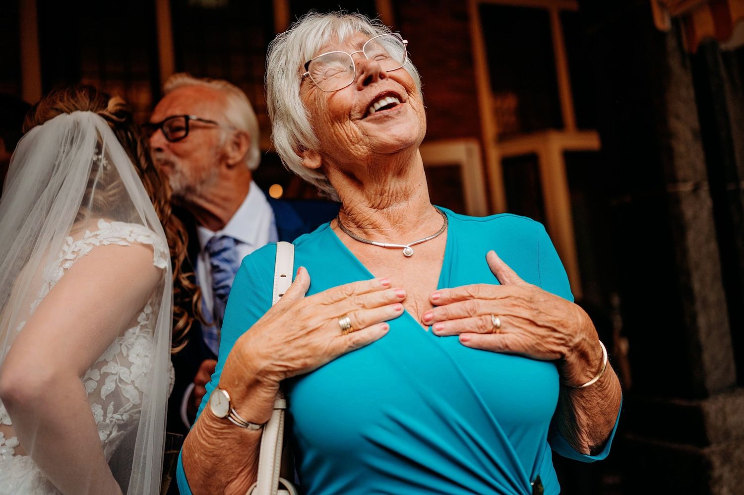 Gasten lachen tijdens sociale bijeenkomst in warme binnenruimte, bruidsfotografie Huize Bergen Vught, Brabant.