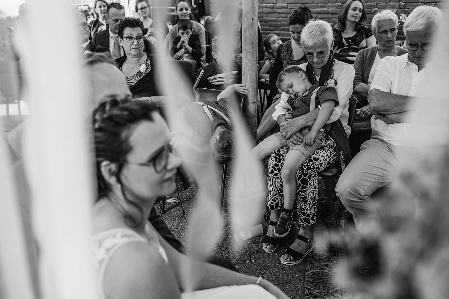 Bruiloftsceremonie met gasten vastgelegd in zwart-wit fotografie, trouwfotografie Brabant.