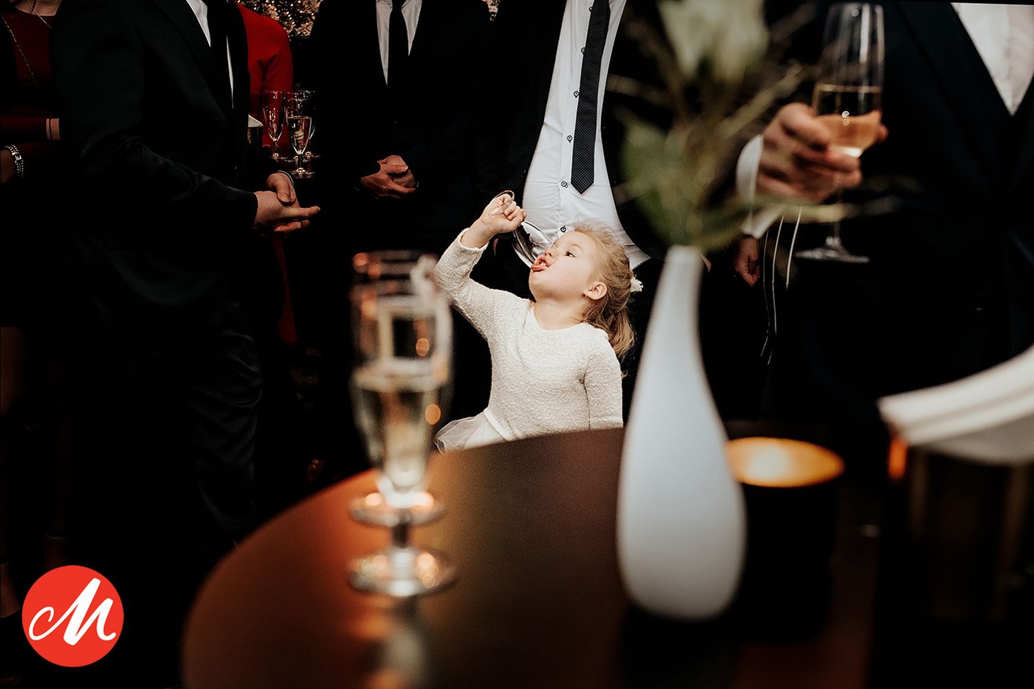 Sfeervolle receptie met gasten die drinken vasthouden in dimly lighting, bruidsfotografie Brabant