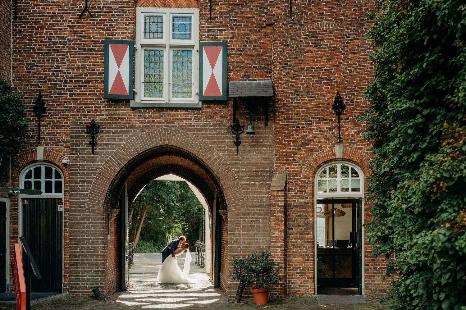 Historische bakstenen gevel met boog en ramen versierd, bruidsfotografie Kasteel Maurick Vught, Brabant.