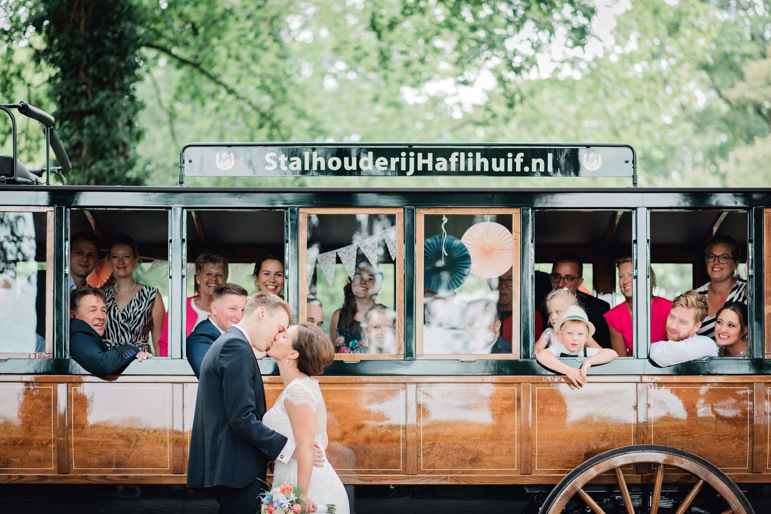 Vintage houten trolley met passagiers tijdens bruiloft, trouwfotografie Brabant.