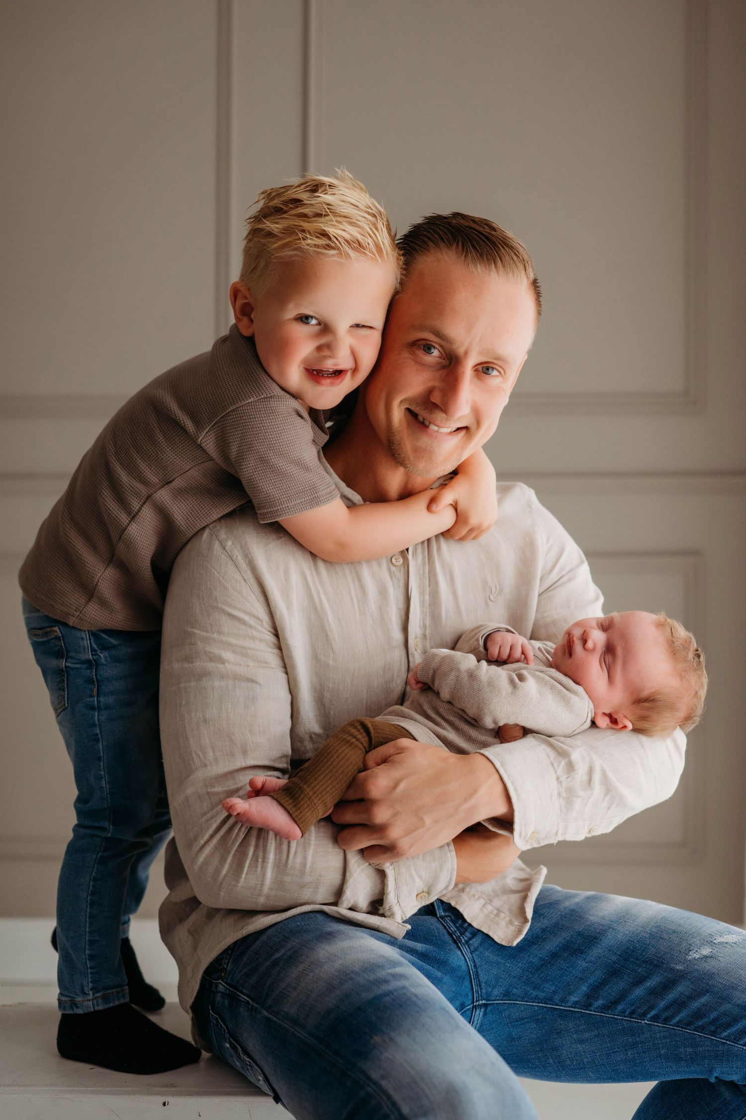 Vrolijk familiemoment met kinderen en ouder op lichte achtergrond, familieshoot Brabant