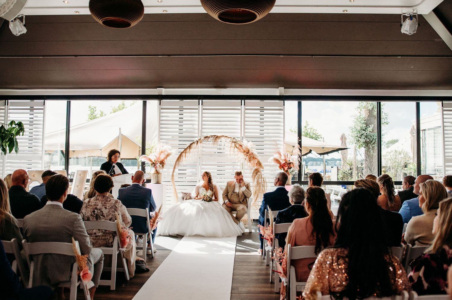 Buitenceremonie in moderne zaal met gasten in rijen, bruidsfotografie IJM IJzereman Vught, Brabant.