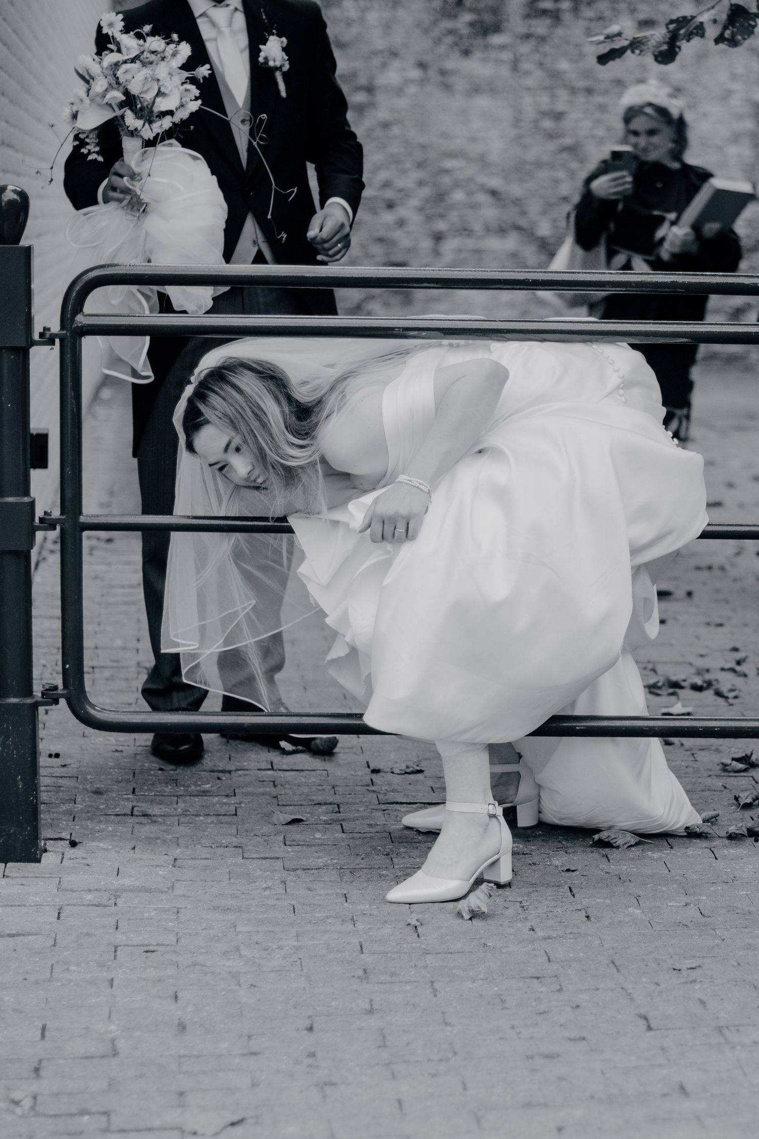 Zwart-wit trouwfoto van jurk en schoenen op bakstenen vloer, bruidsfotografie Noordbrabants Museum Den Bosch, Brabant.