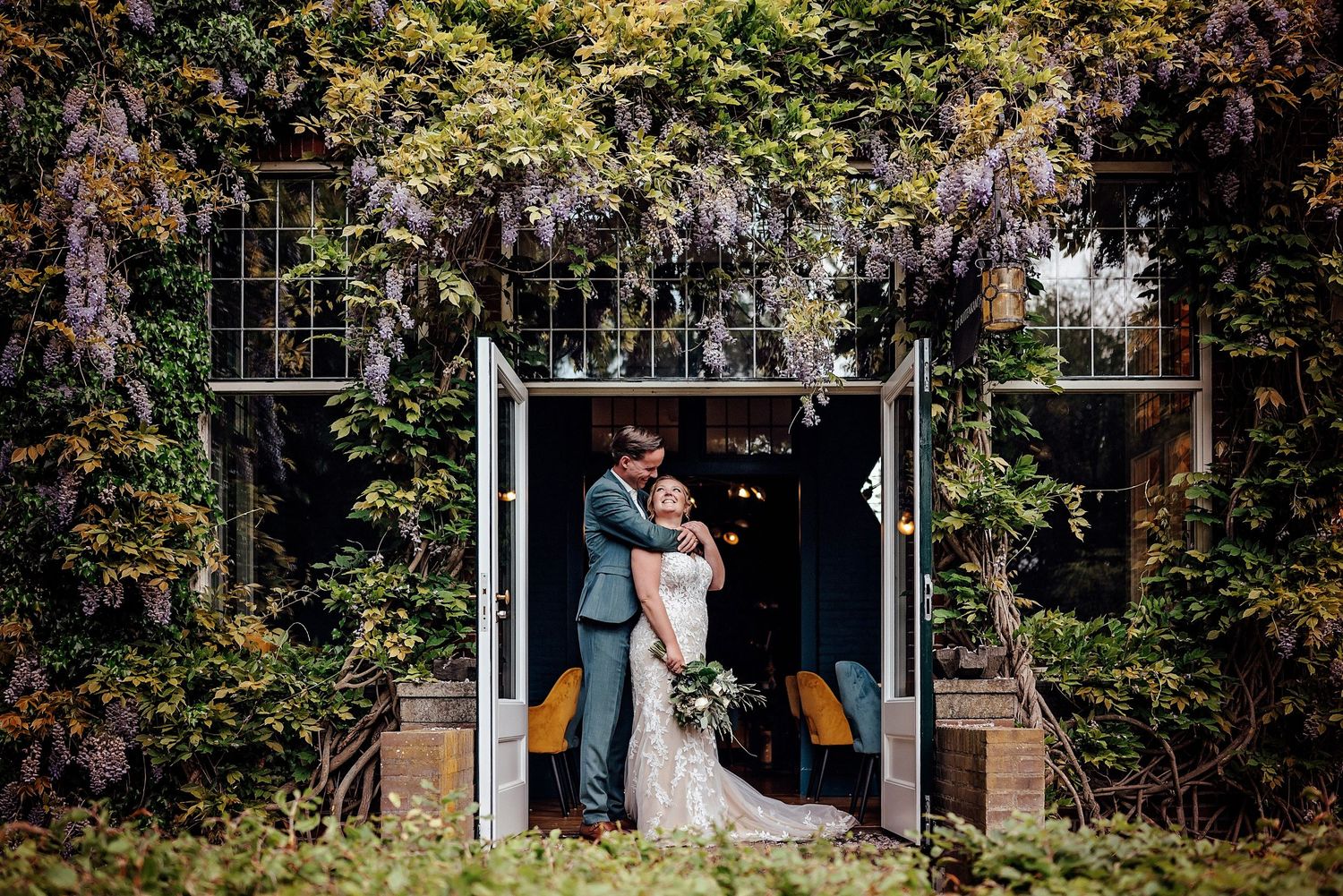 Ceremonie met natuurlijke boog omgeven door weelderige tuin, bruidsfotografie Brabant