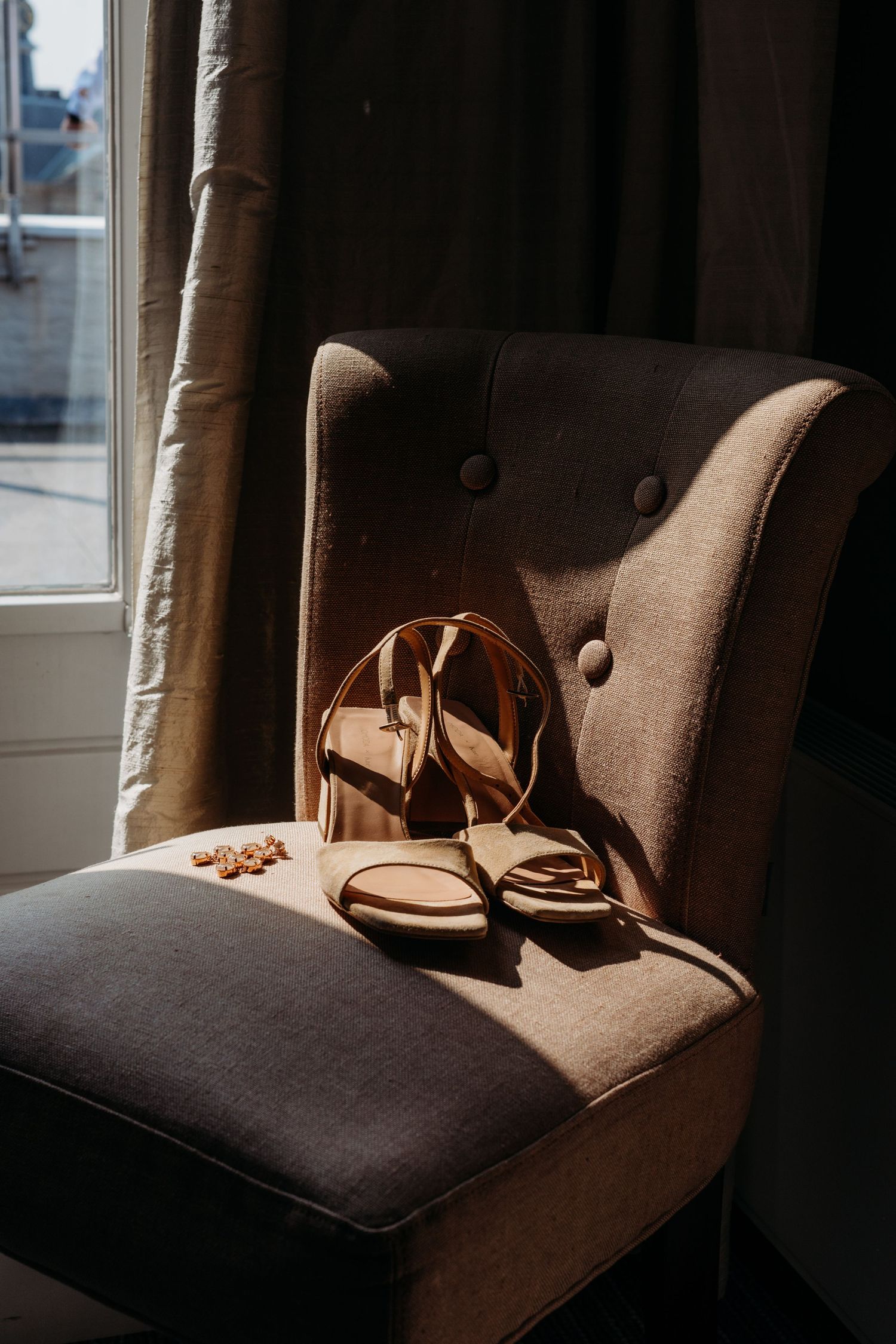 Bruidsdetails met trouwschoenen op stoel in sfeervol licht, stijlvolle bruidsfotografie in Den Bosch en omgeving Brabant.