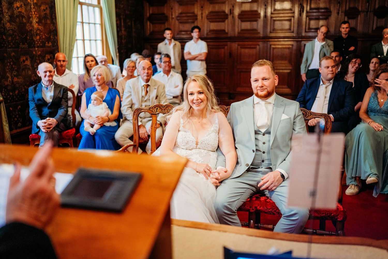 Trouwceremonie in historische houten zaal met gasten, romantische bruidsfotografie in Den Bosch en omgeving Brabant.