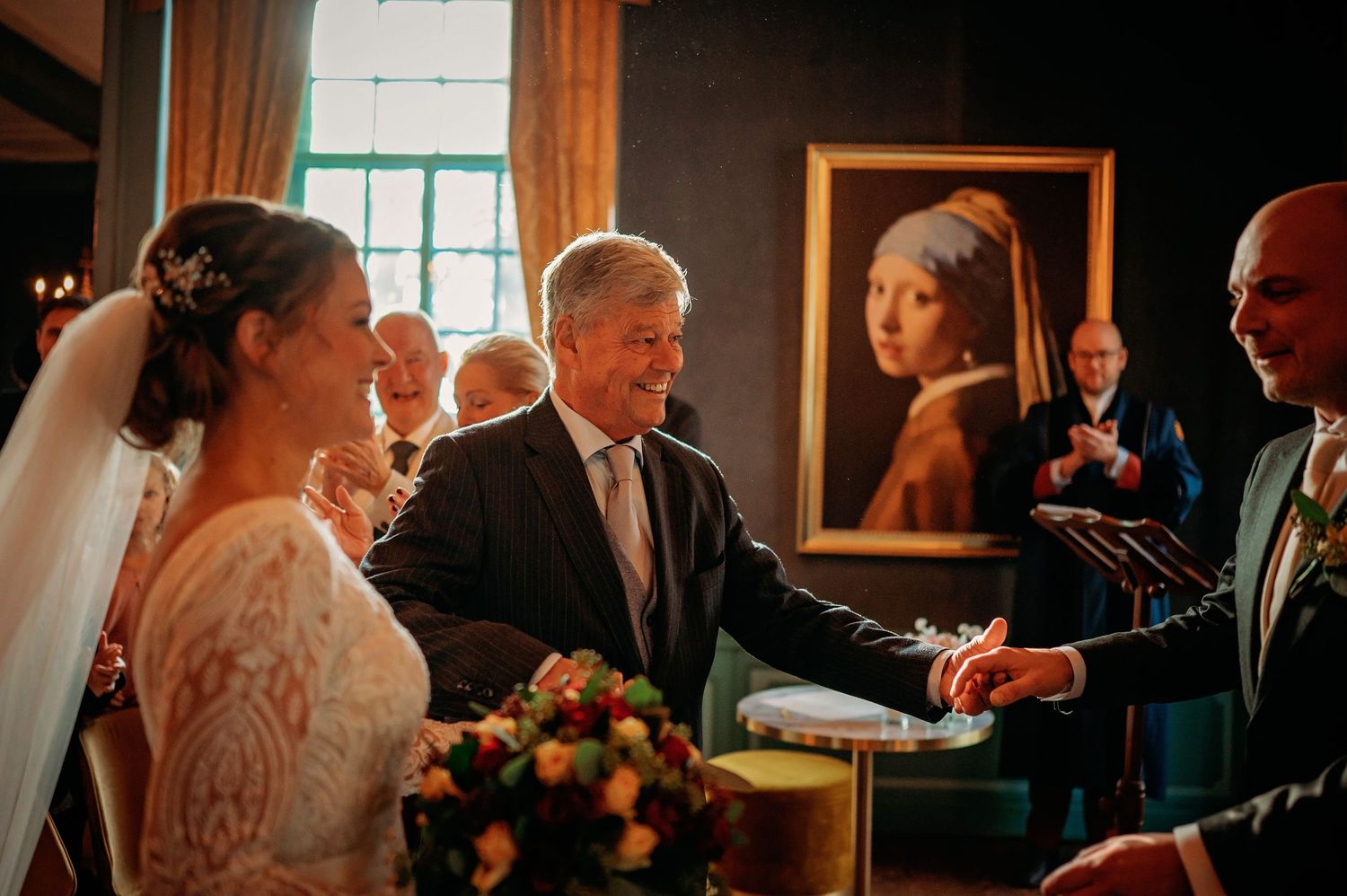 Bruidspaar wisselt ringen tijdens ceremonie met gasten, romantische bruidsfotografie bij Kasteel Wijenburg Echteld, Brabant.
