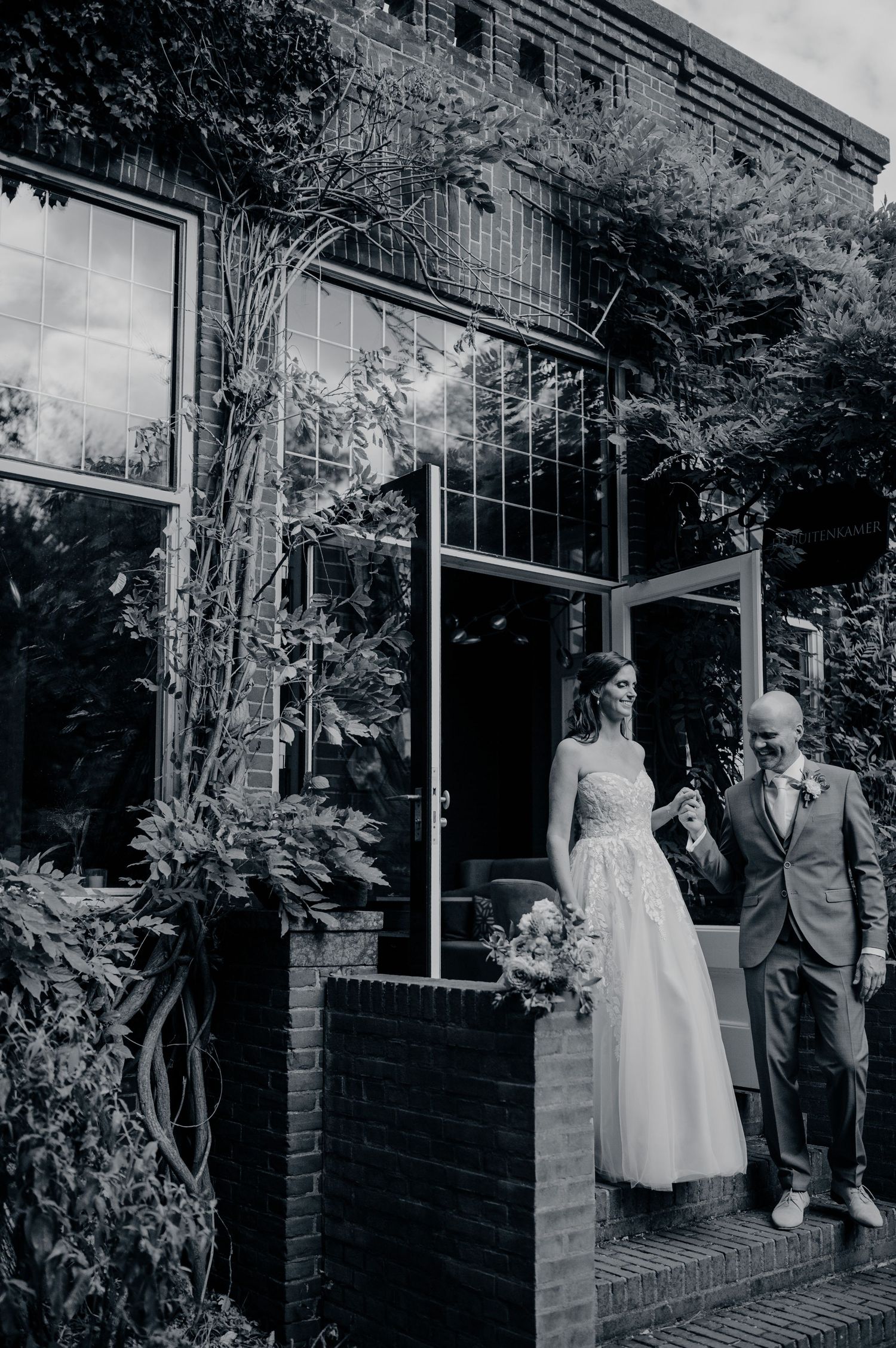 Zwart wit trouwfoto van bruidspaar bij een landelijke locatie, tijdloze bruidsfotografie in Brabant op Huize Bergen