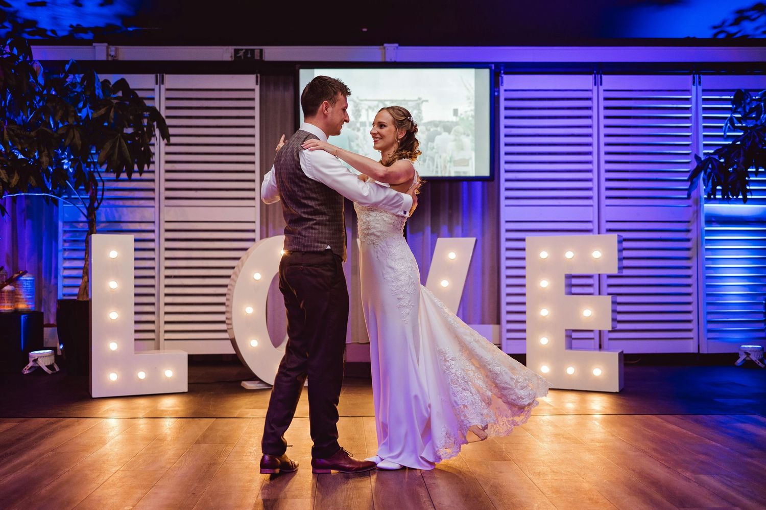 Dansvloer bij bruiloft verlicht met blauw licht en LOVE letters, bruidsfotografie Vught, Brabant.