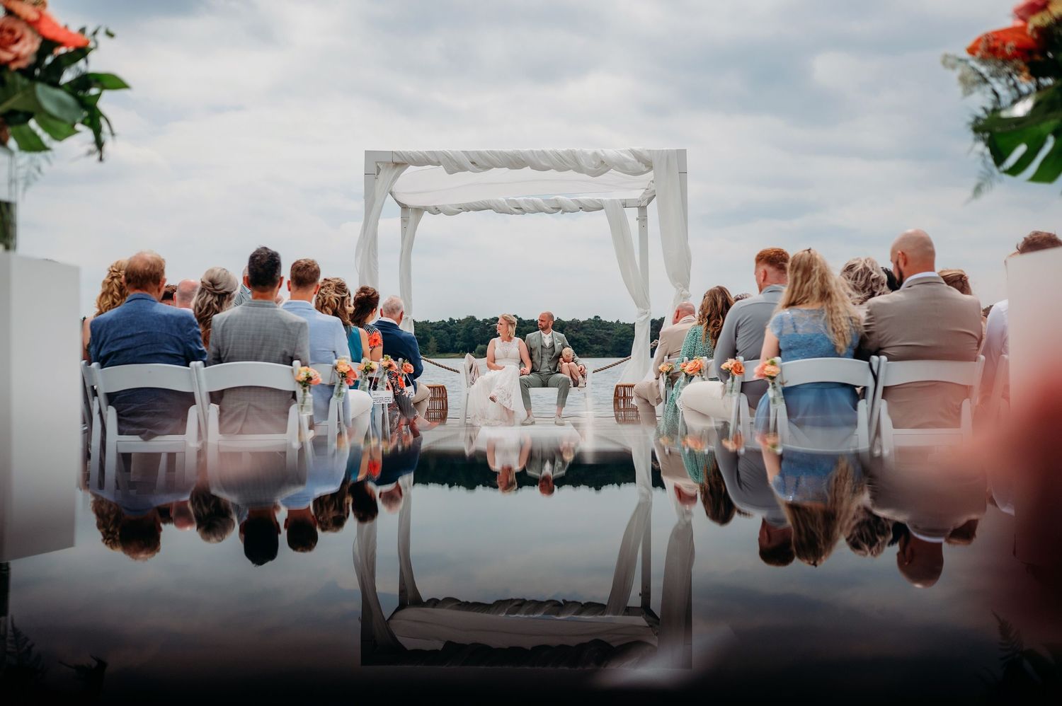 Buitenceremonie op strand met witte stoelen en uitzicht op water, bruidsfotografie IJM IJzereman Vught, Brabant.