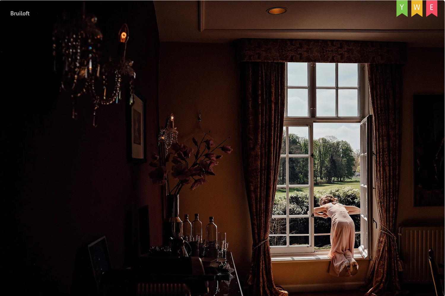 Sunlight streams through a window in a dimly lit interior room with elegant decor.