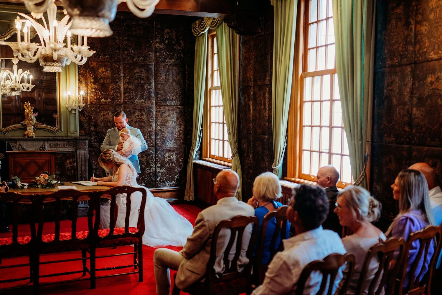 Trouwceremonie in stijlvolle zaal met hout en kroonluchter, romantische bruidsfotografie in Den Bosch en omgeving Brabant.
