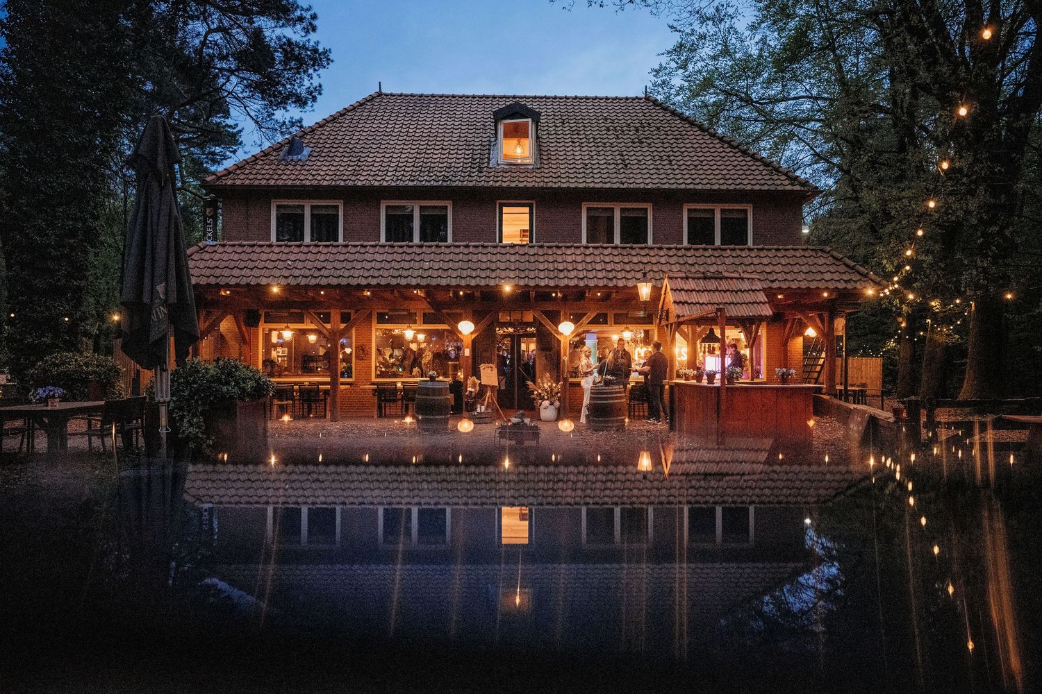 Sfeervolle avond bij trouwlocatie aan het water met lichtjes, bruidsfotografie bij Mr van Eijck Oisterwijk, Brabant.