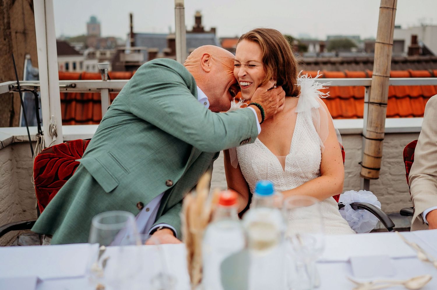 Bruidspaar geniet van intiem moment tijdens diner op rooftop, romantische bruidsfotografie in Den Bosch en omgeving Brabant.