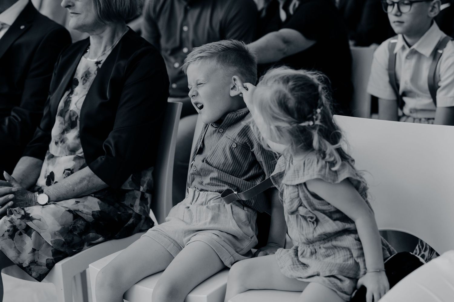 Gezinsmoment buiten, ouders en kinderen samen spelend in zonnige tuin, familieshoot Brabant