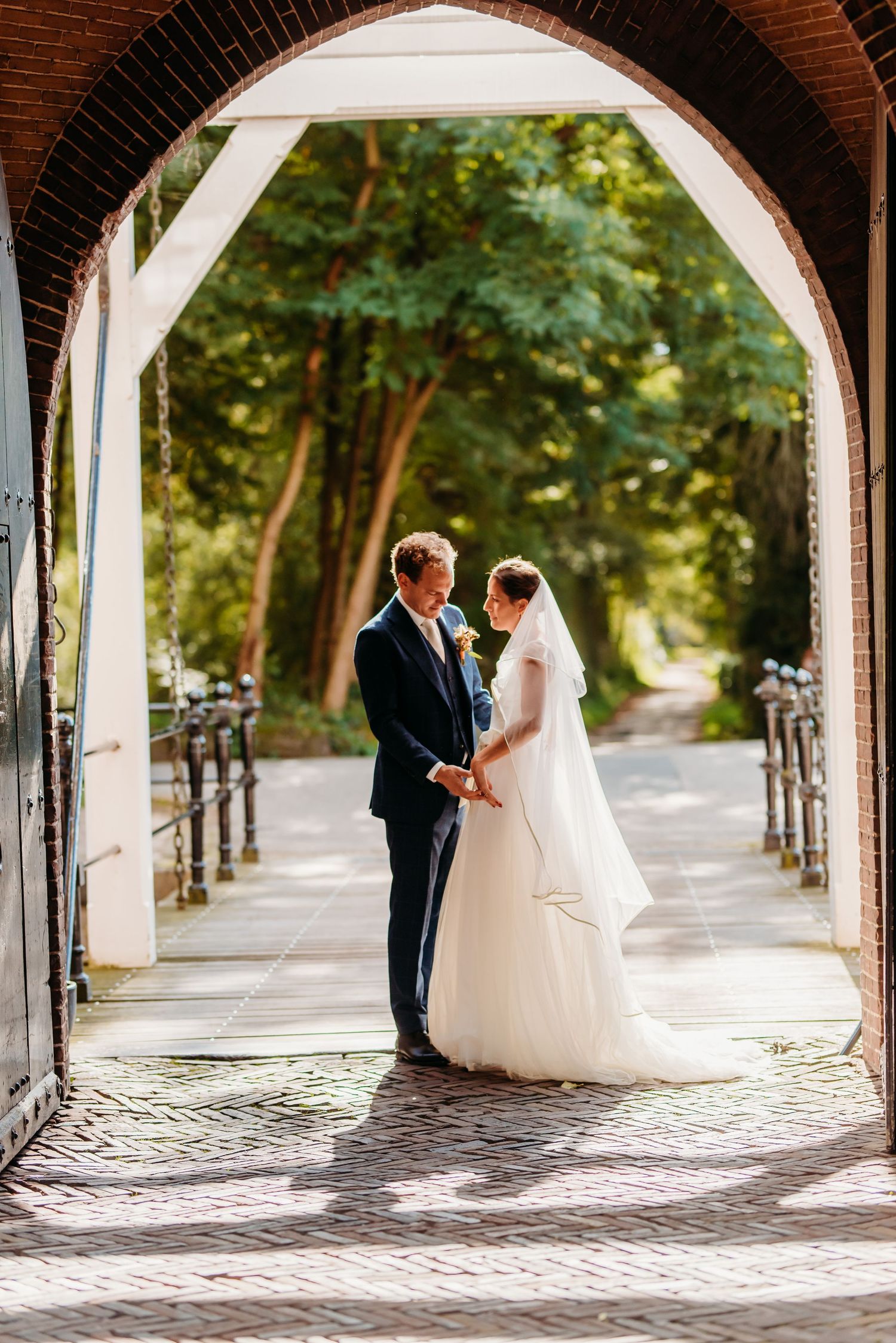 Romantische booggang met bakstenen kolommen en kasseien, bruidsfotografie Kasteel Maurick Vught, Brabant.Romantische booggang met bakstenen