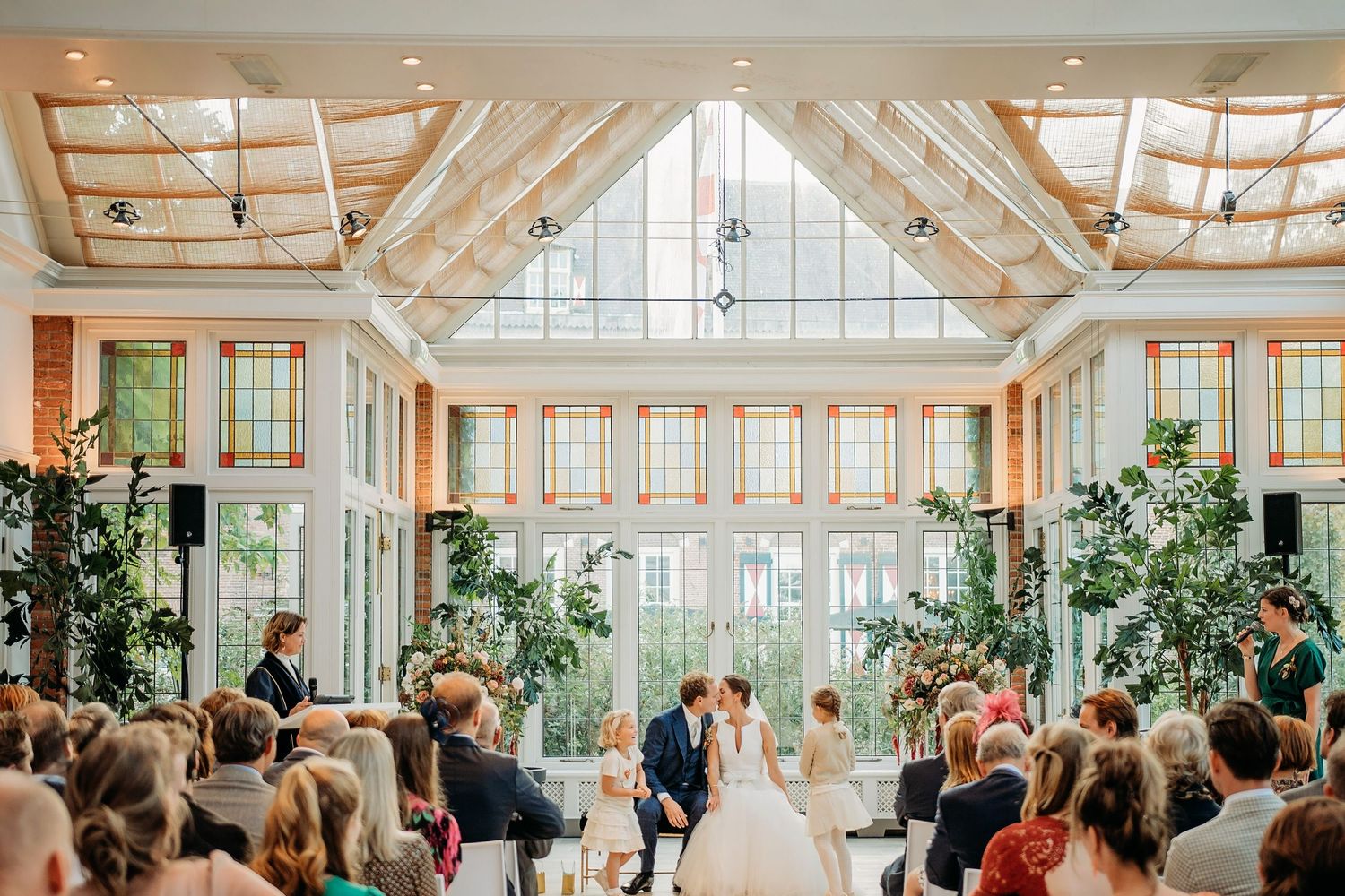 Ceremonie in volle zaal met gasten zittend, bruidsfotografie Kasteel Maurick Vught, Brabant.