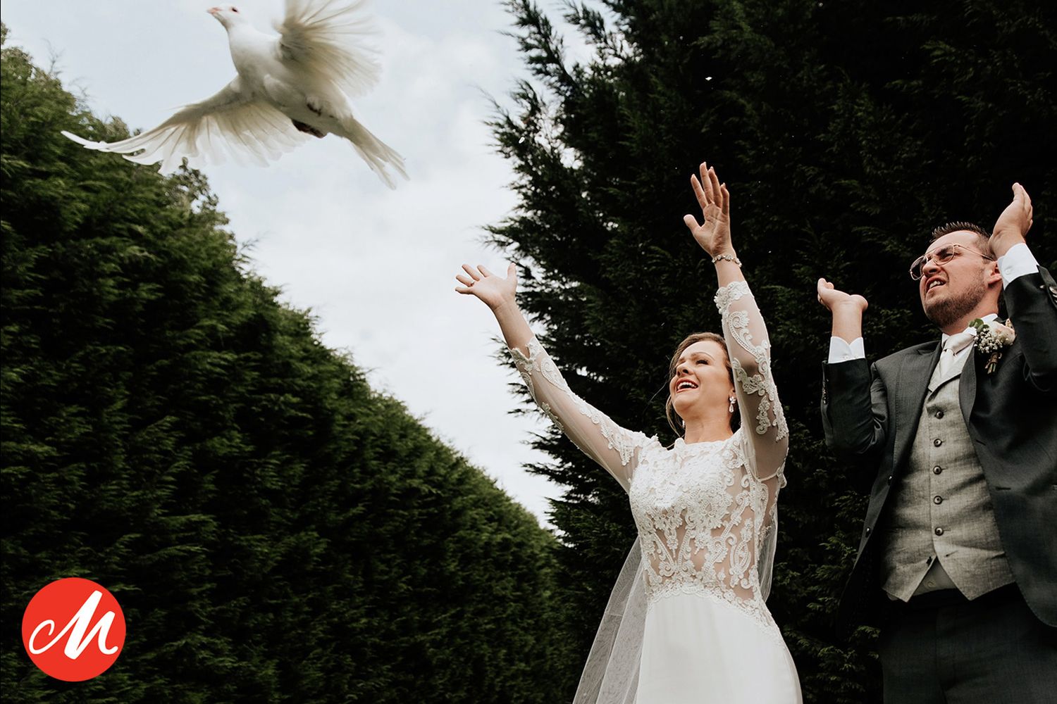 Bruidspaar laat witte duiven vrij tijdens buitenceremonie, bruidsfotografie Brabant