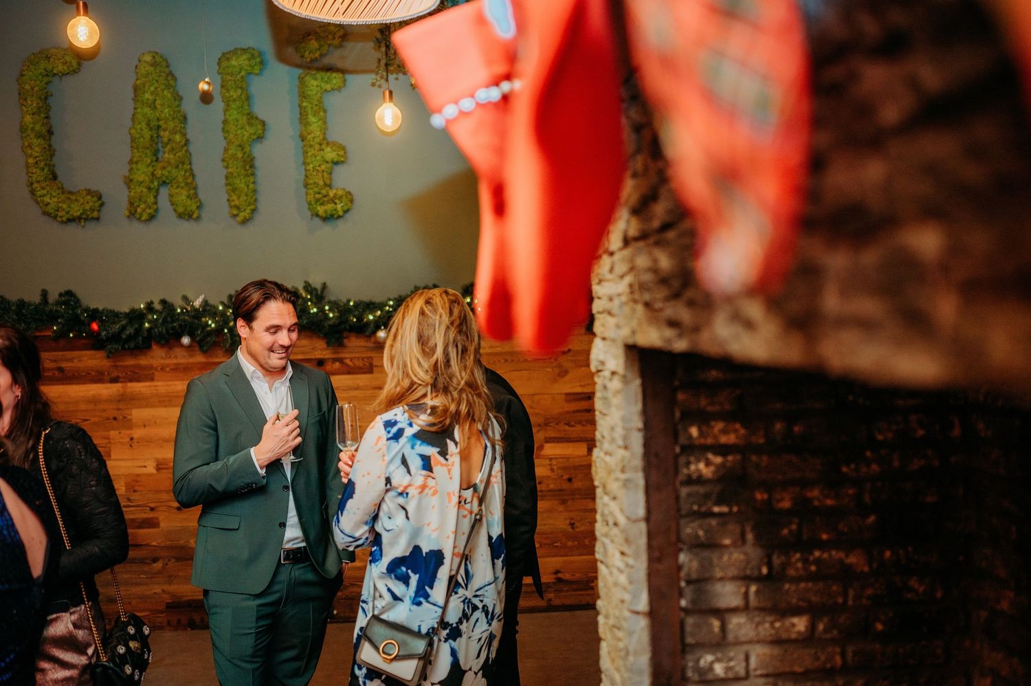 Trouwfeest met lichtjes en bakstenen muur vol sfeer, spontane bruidsfotografie bij Boscafé Oisterwijk, regio Brabant.