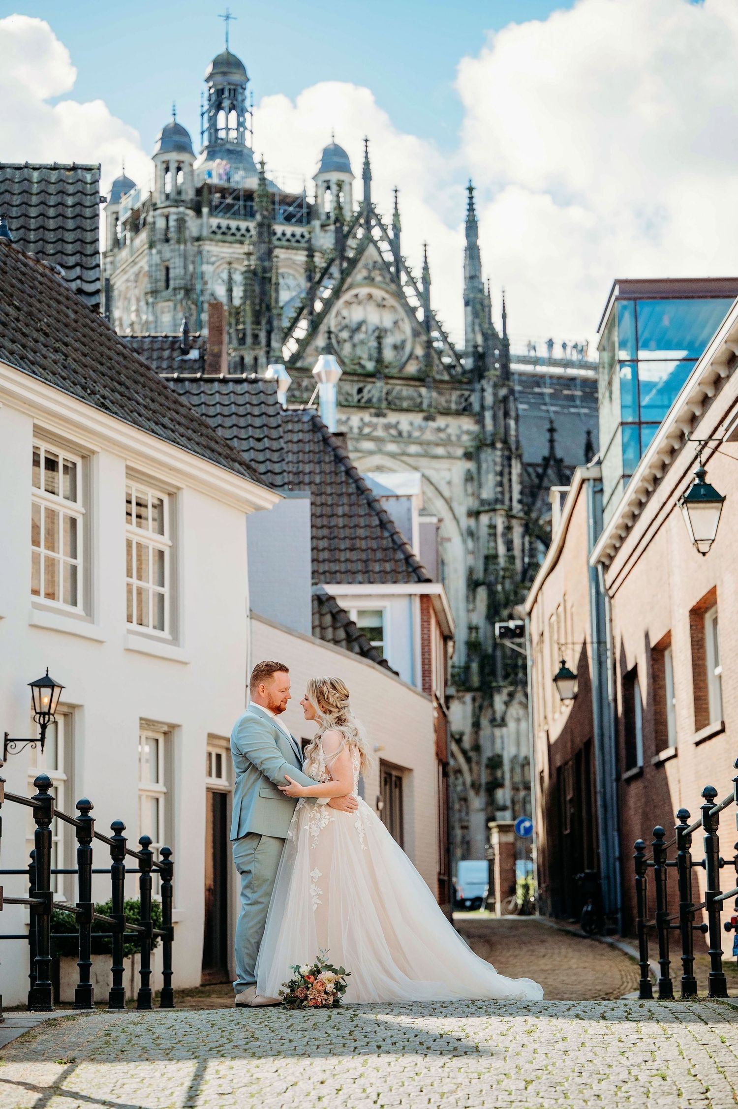 Trouwfoto in sfeervol steegje met gotische torens, romantische bruidsfotografie in Den Bosch en omgeving Brabant.