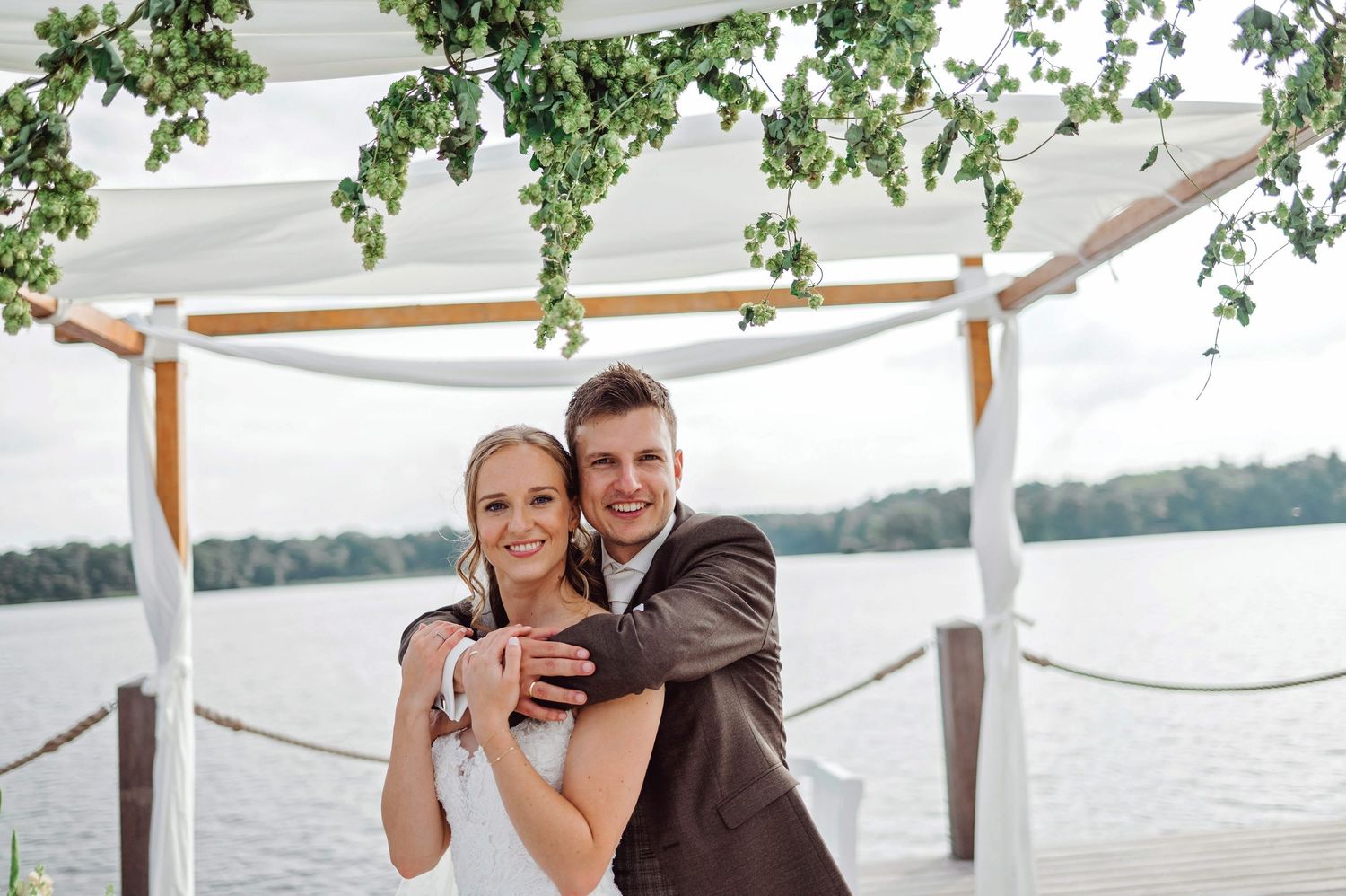 Romantisch bruidspaar onder pergola bij water met groen, bruidsfotografie Vught, Brabant. IJM