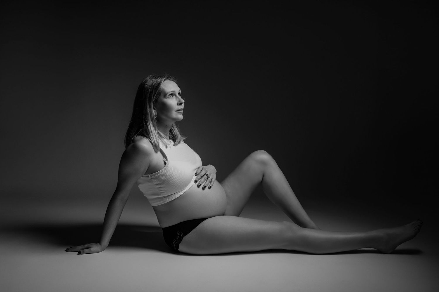 Artistieke zwart-wit zwangerschapsfoto met low-key belichting, zwangerschapsfotografie Brabant