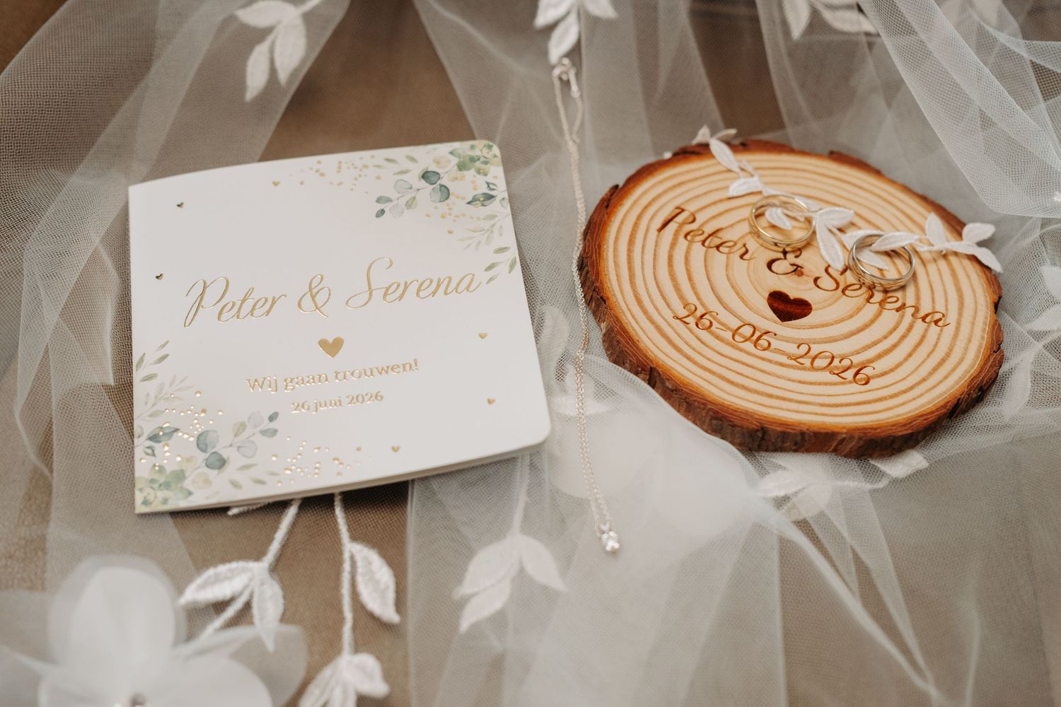 Elegant wedding stationery with floral design and rustic wood slice ring holder engraved with Peter and Serena.