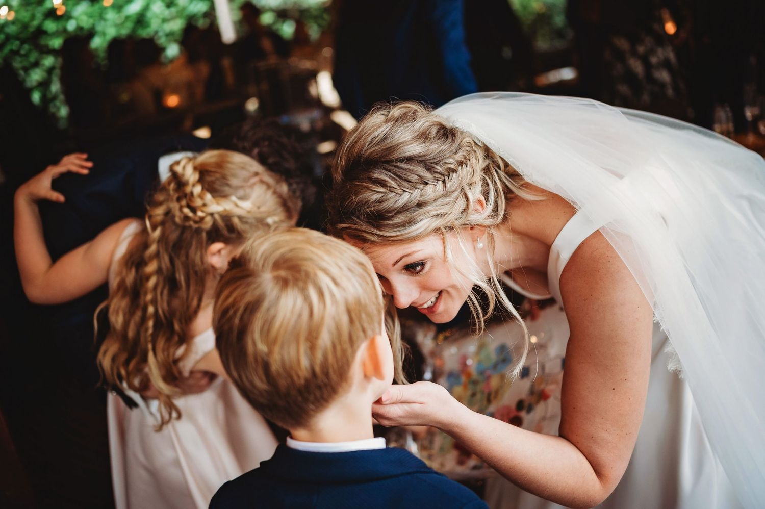 Teder trouwmoment tussen bruid en kind, spontane bruidsfotografie tijdens bruiloft in regio Den Bosch, Vught, Noord Brabant.