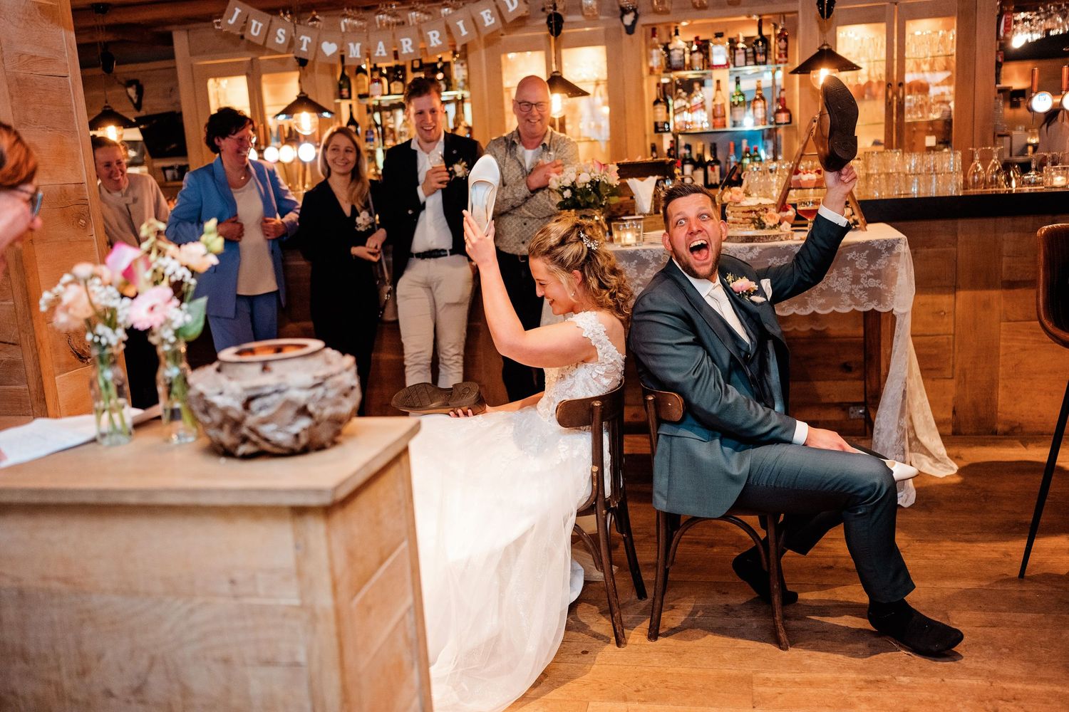 Bruiloftsgasten dansen op houten vloer in warme schuur, spontane bruidsfotografie bij Mr van Eijck Oisterwijk, Brabant.