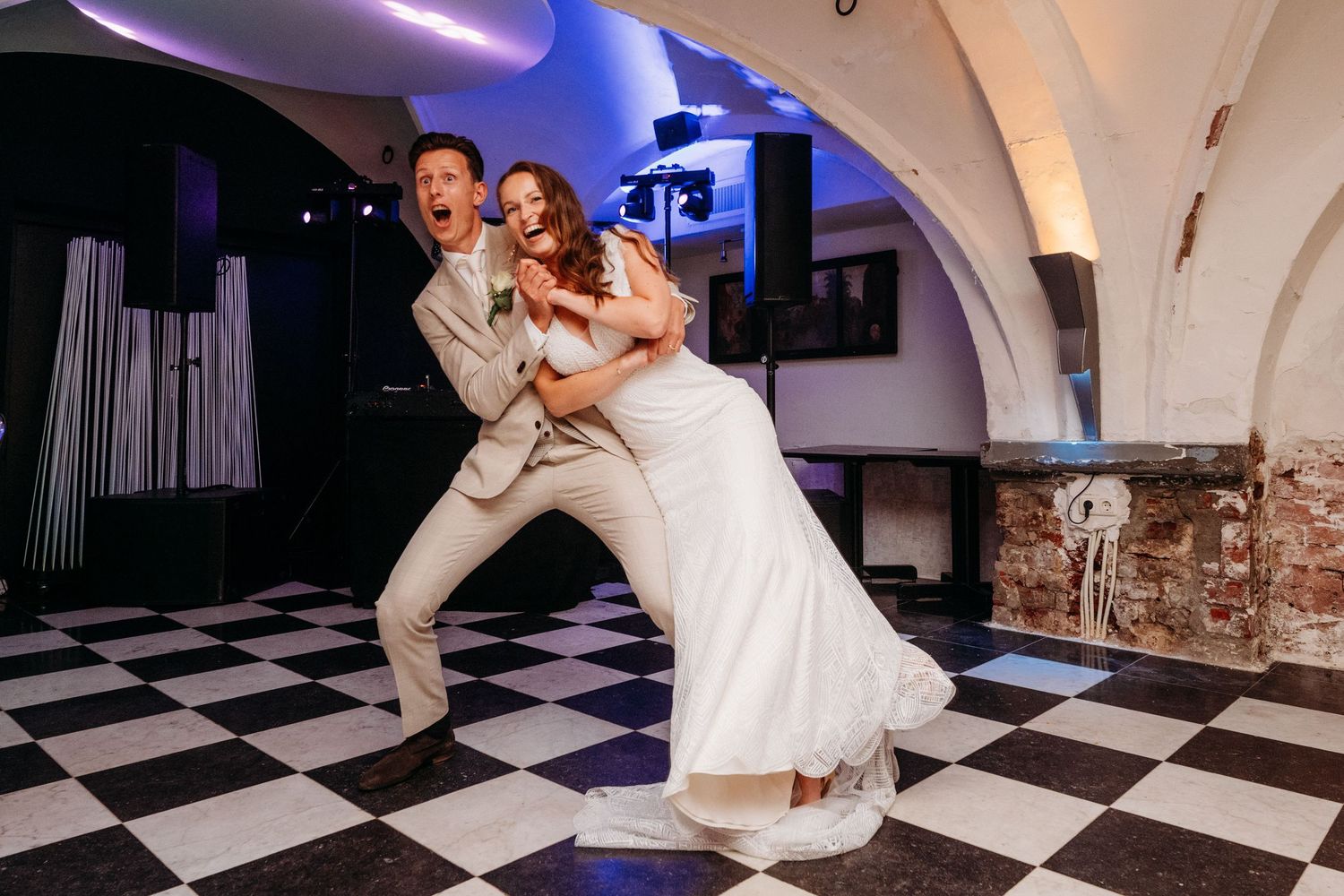Bruidspaar danst op zwart wit vloer tijdens trouwfeest, sfeervolle bruidsfotografie in regio Den Bosch, Hotel Central