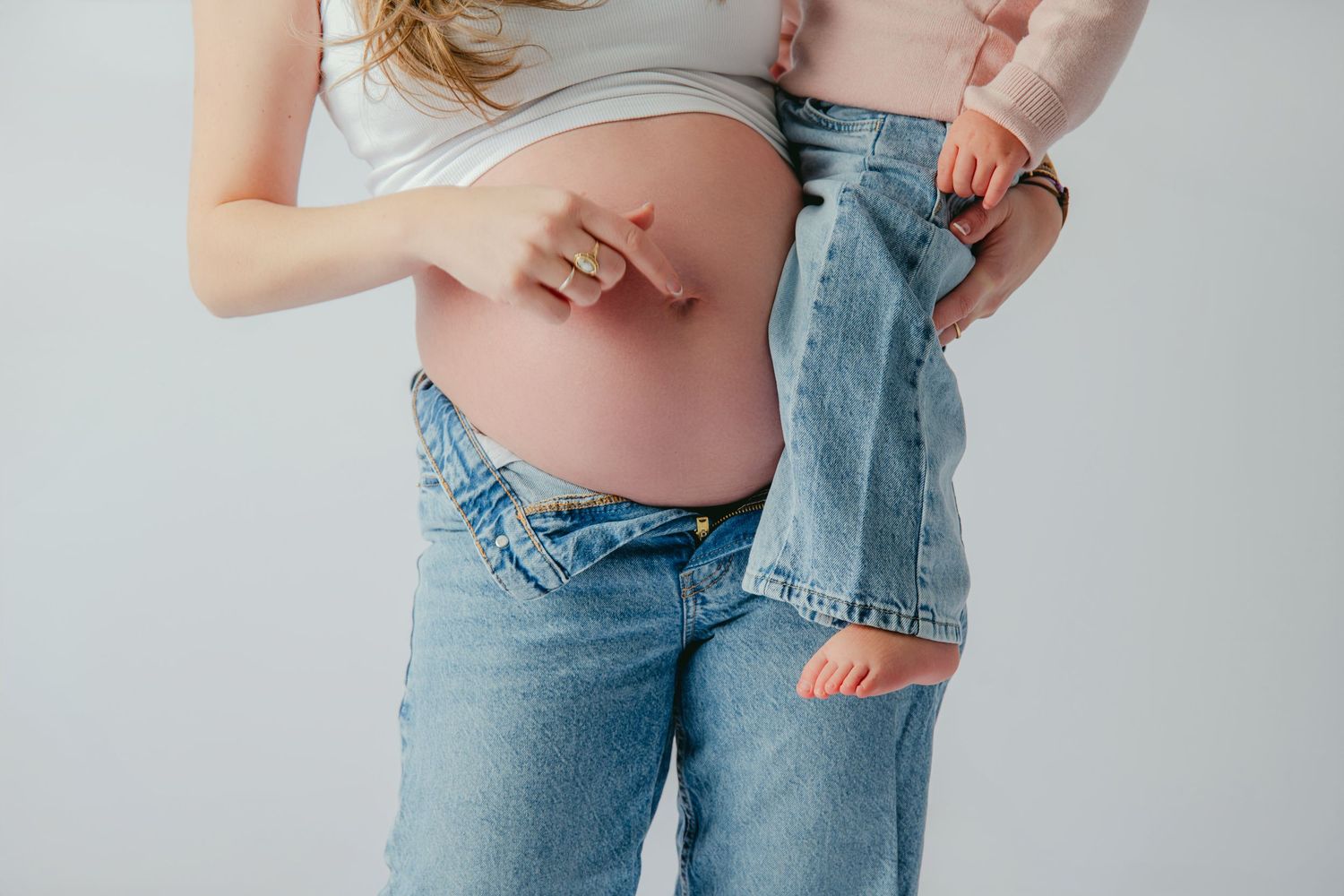 Zwangerschapsfotografie met casual poses in denim en lichte kleding, zwangerschapsfotografie Brabant