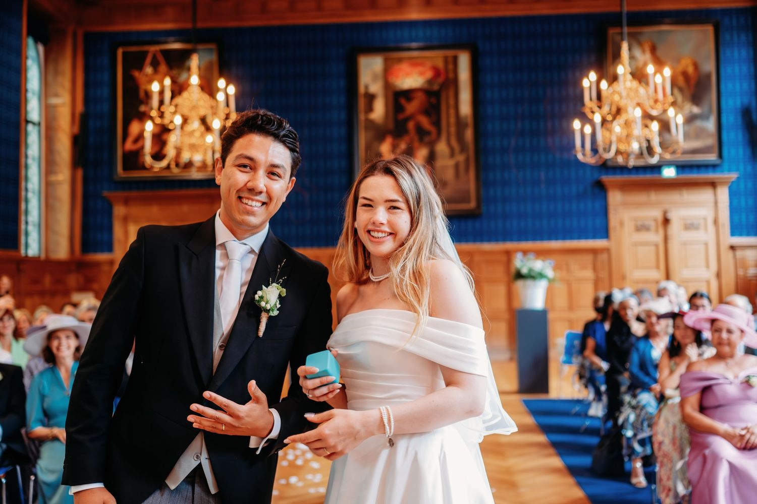 Bruiloftsfeest in elegante balzaal met kristallen kroonluchters en blauwe muren, bruidsfotografie Noordbrabants Museum Den Bosch, Brabant.