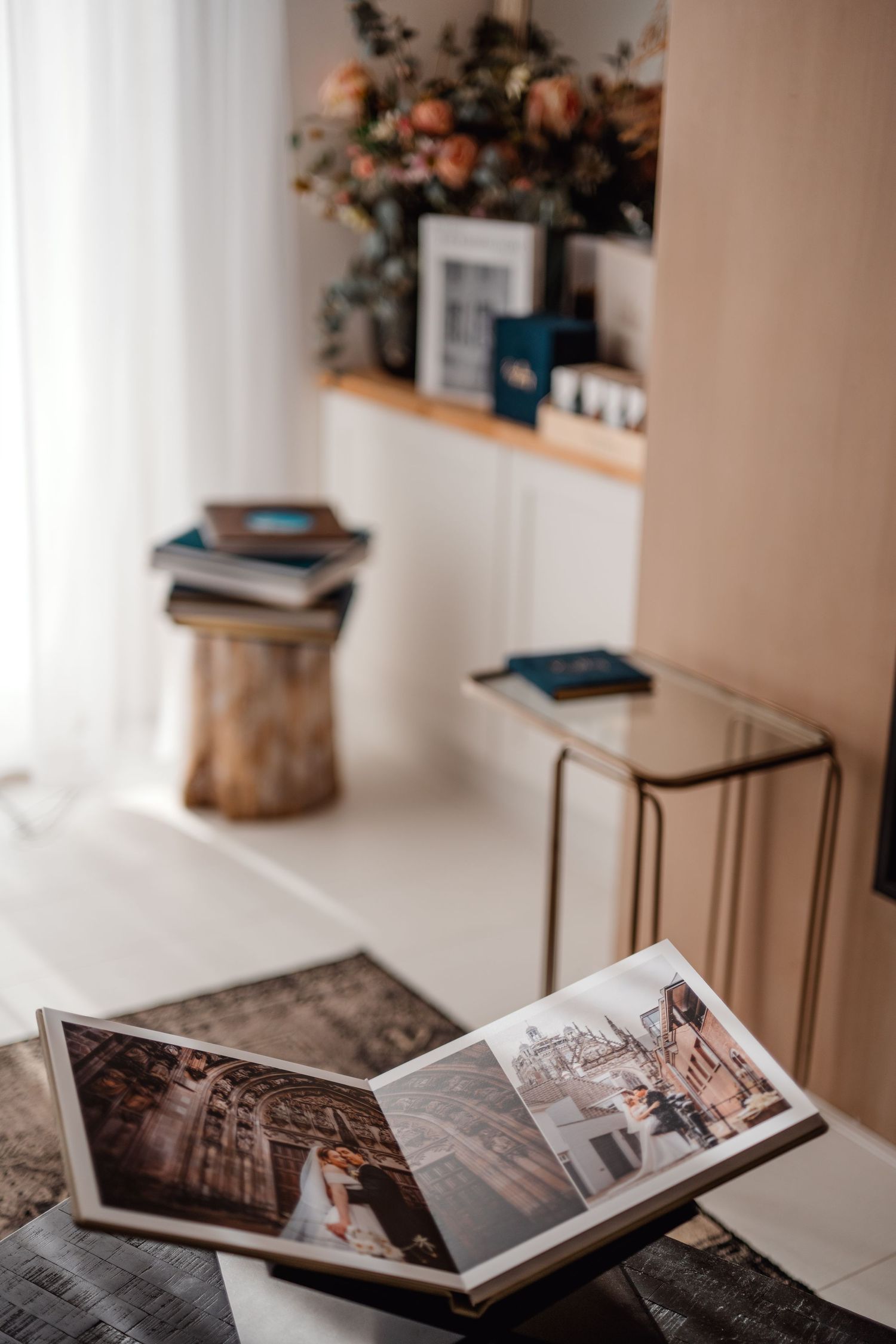Bruiloftsfotoalbums en boeken artistiek geplaatst op witte ondergrond met bloemdecor, branding fotografie Brabant