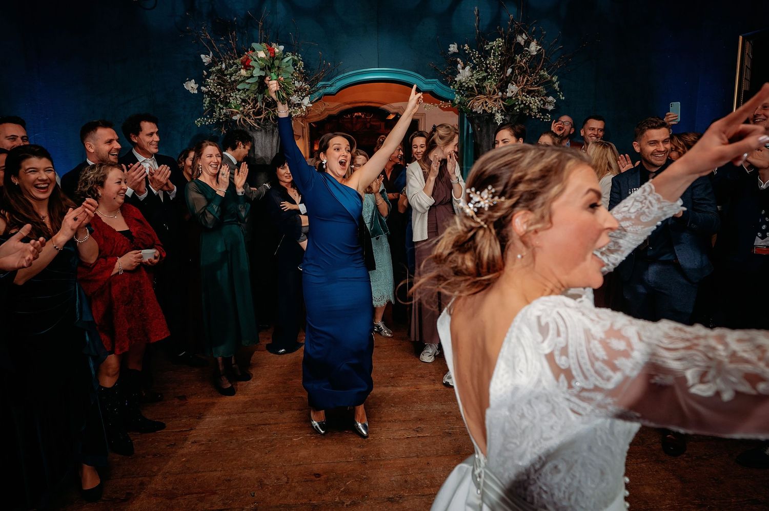 Bruiloftsgasten dansen op houten dansvloer tijdens avondfeest, spontane bruidsfotografie bij Kasteel Wijenburg Echteld, Brabant.