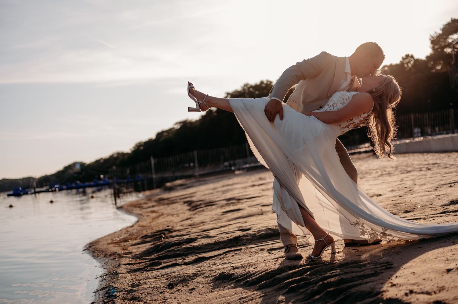 Romantische kus van een bruidspaar tijdens een fotoshoot aan het water in Brabant.