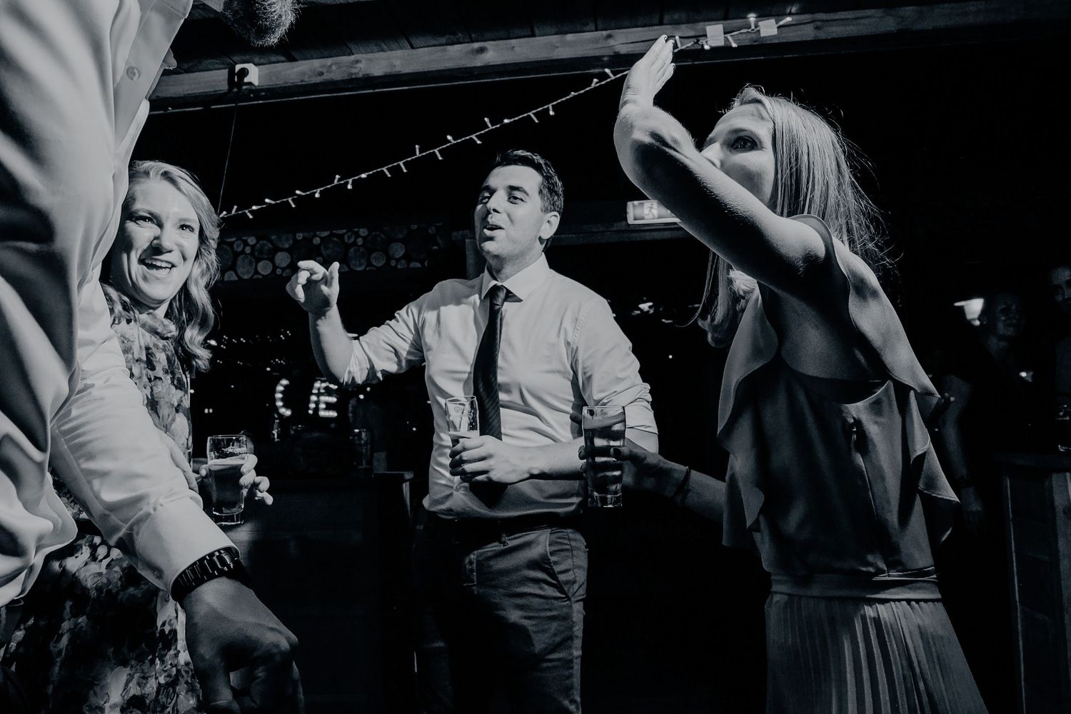 Zwart wit moment van dansende gasten tijdens feestavond, pure en tijdloze trouwfotografie