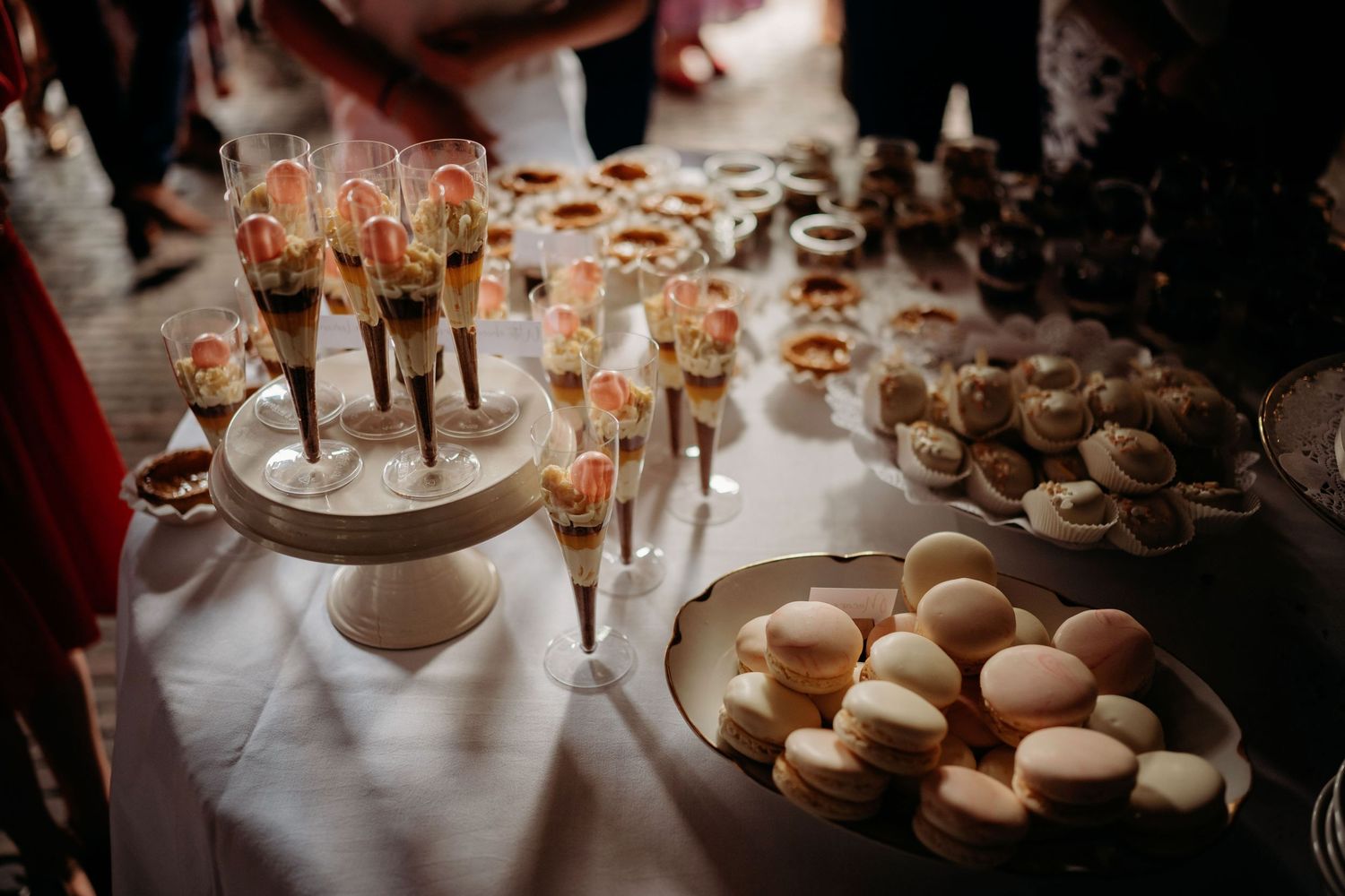 An elegant wedding dessert table with macarons, champagne flutes, and assorted sweet treats.