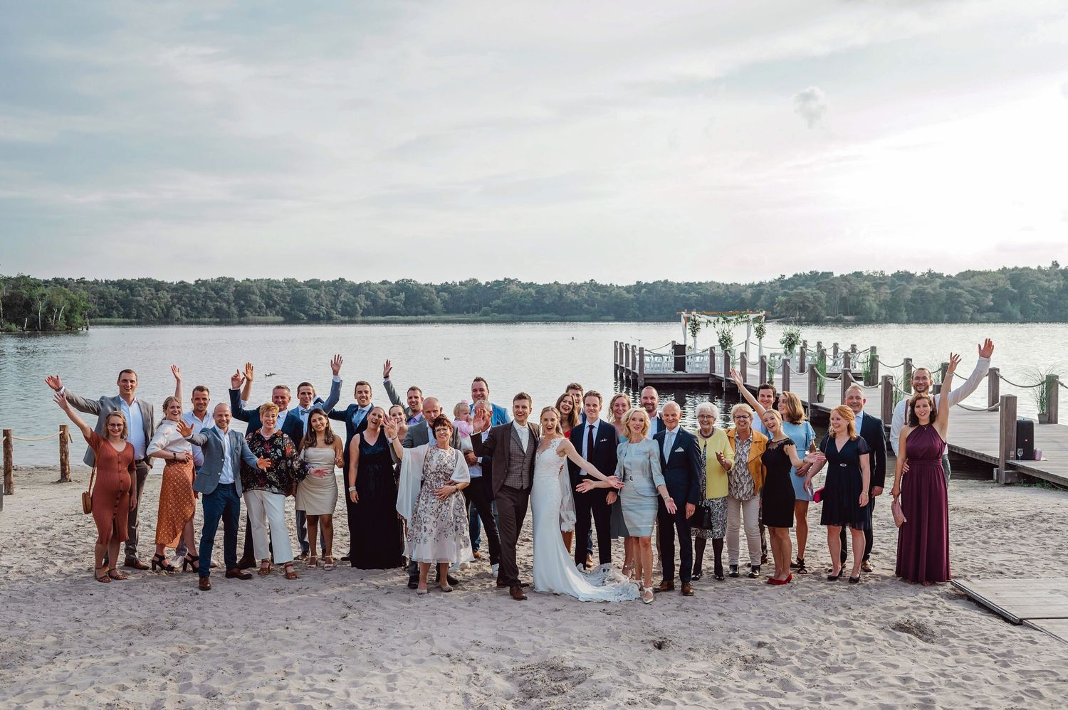 Groep bruiloftsgasten opgestelde foto langs waterkant, bruidsfotografie Vught, Brabant.IJM