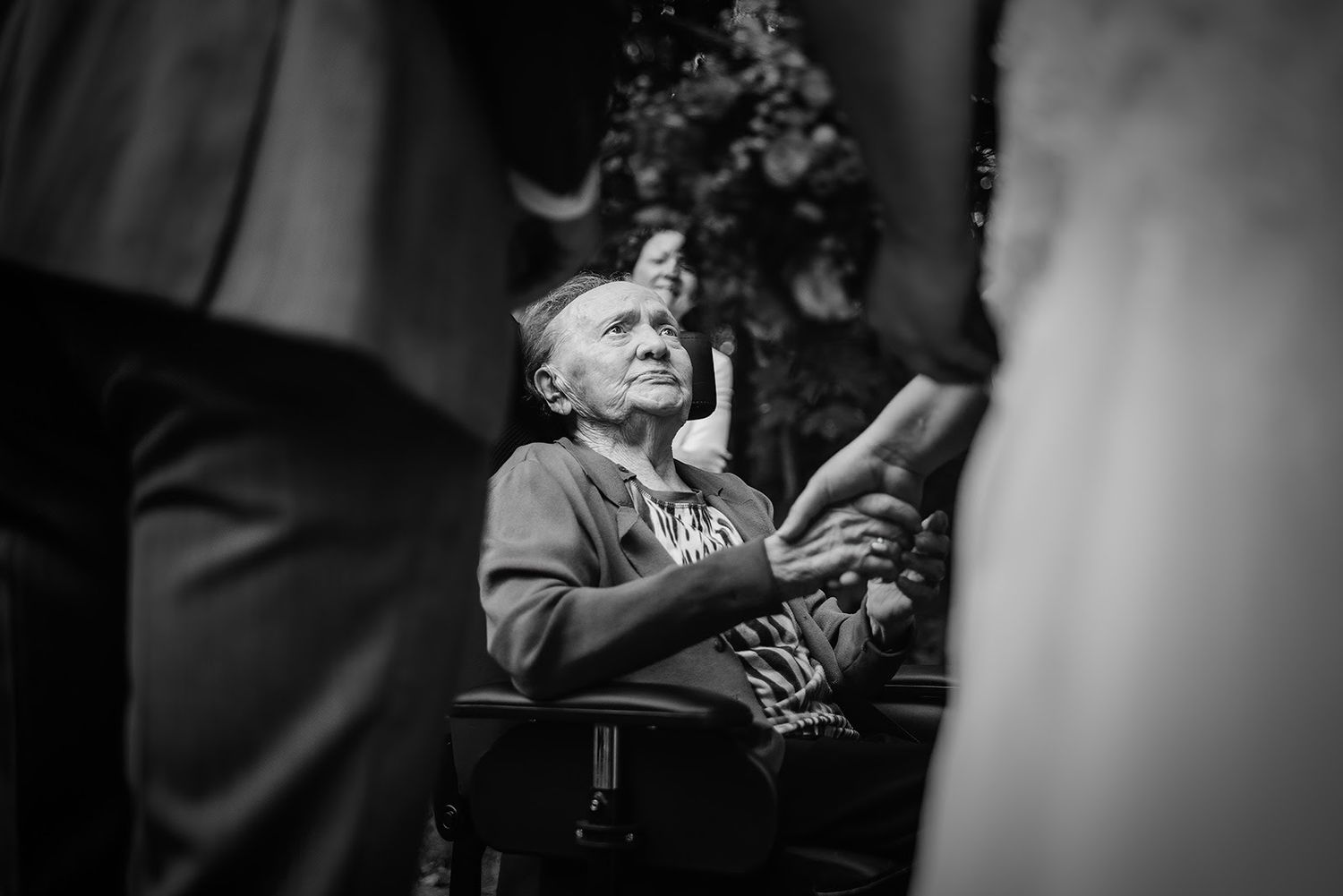Zwart-wit trouwfoto met emotionele reacties en omhelzingen van gasten, ideale reportagefoto in Den Bosch.