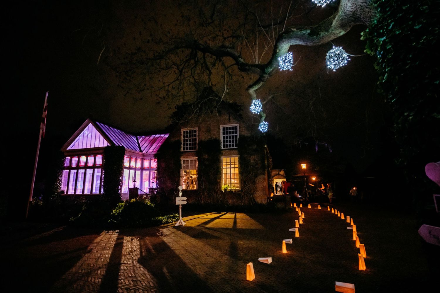 Avondreceptie met paarse verlichting en lampionnen, bruidsfotografie Kasteel Maurick Vught, Brabant.