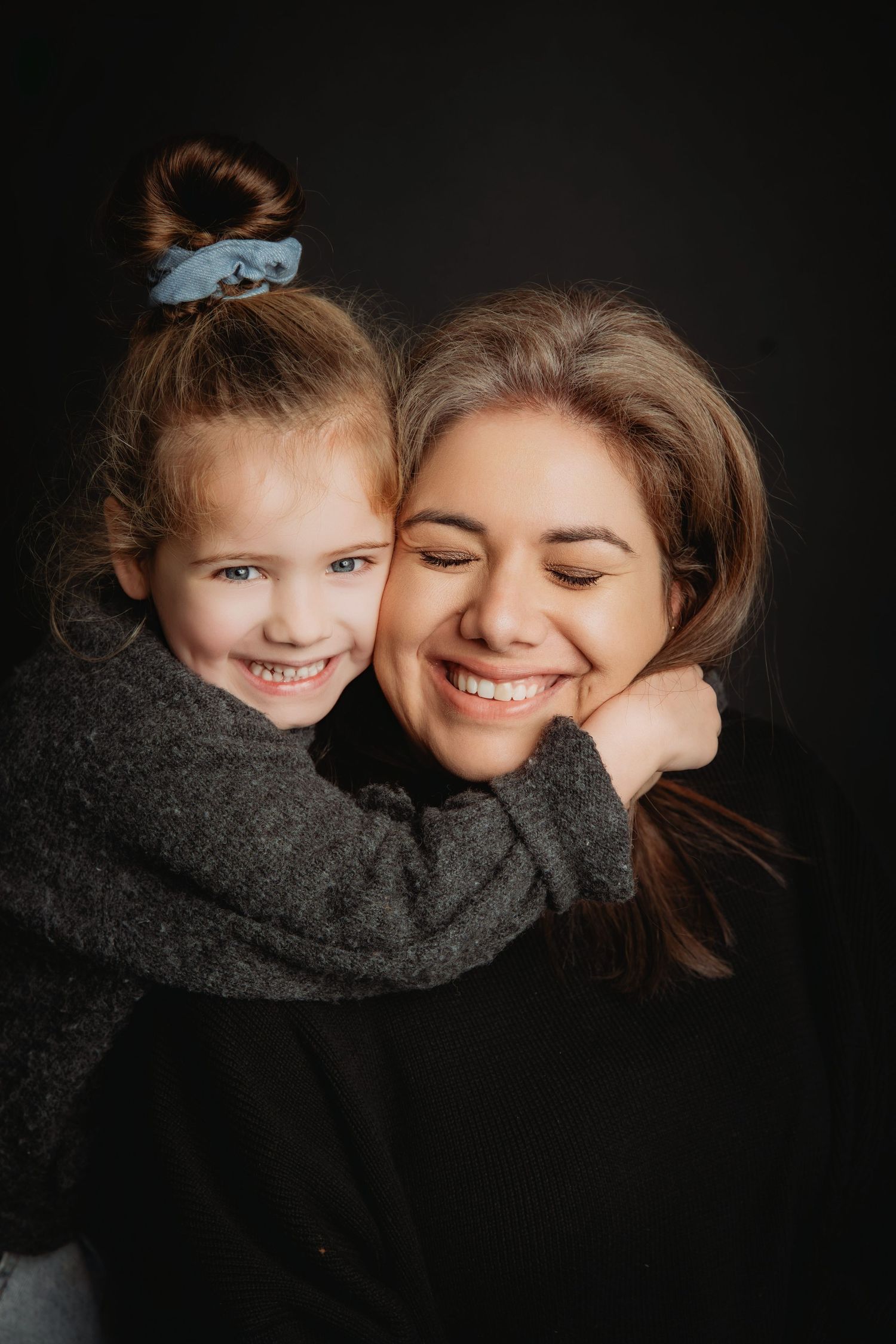 Intieme portretserie met warme omhelzingen tegen donkere achtergrond, familie- en portretfotografie Brabant