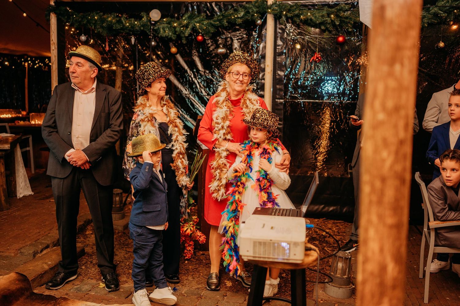 Bruiloftsgasten vieren feest onder lichtjes en rustieke styling, spontane bruidsfotografie bij Boscafé Oisterwijk, regio Brabant.