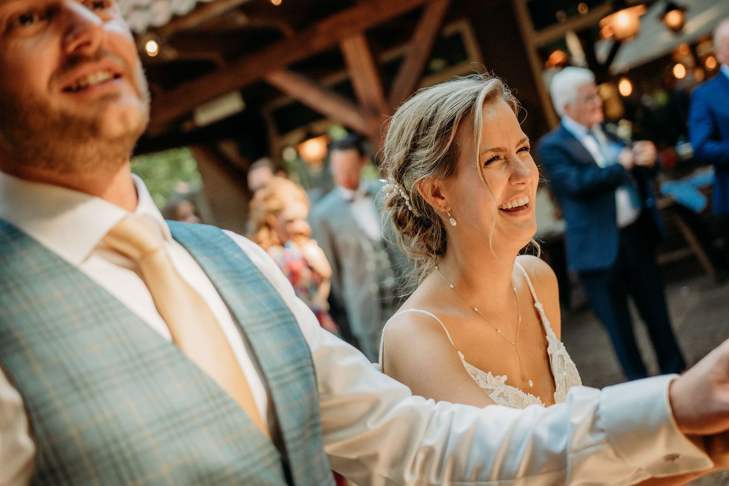 Bruiloftsgasten dansen en lachen tijdens feest binnen, spontane bruidsfotografie bij Mr van Eijck Oisterwijk, Brabant.