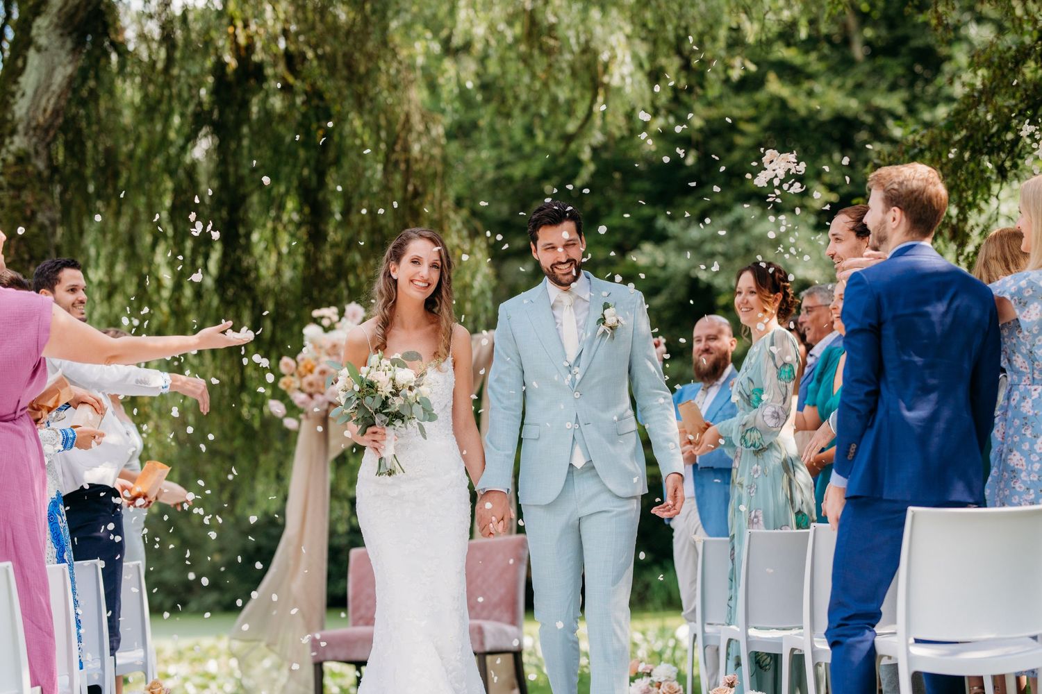 Gasten vieren met confetti en sterretjes tijdens zomerse ceremonie buiten, bruidsfotografie Huize Bergen Vught, Brabant.