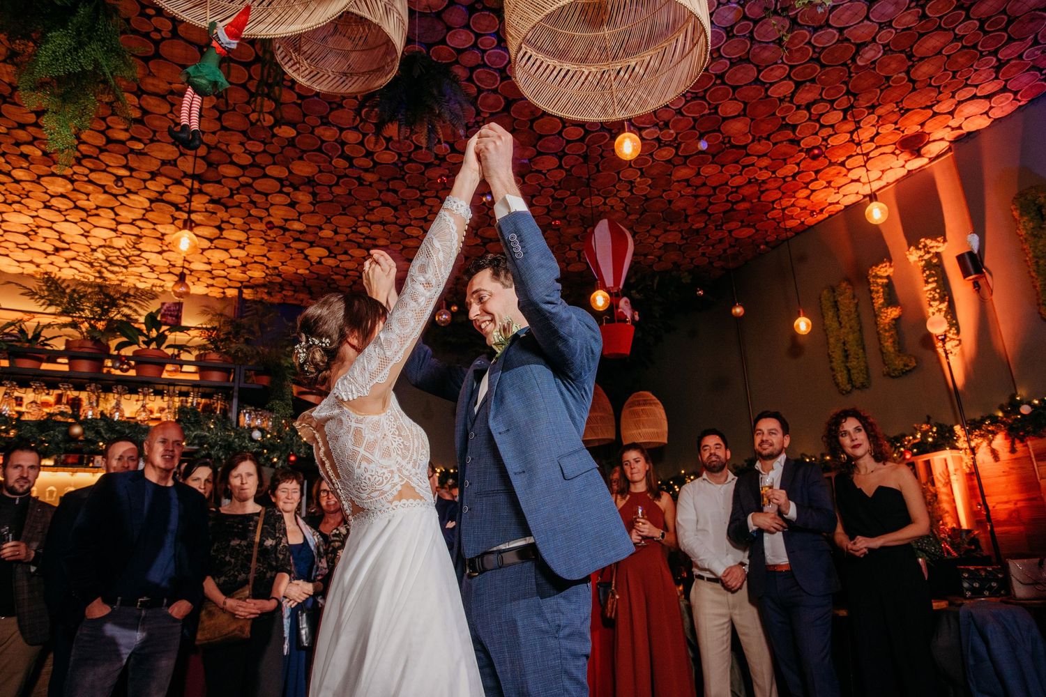 Bruidspaar danst onder rood sfeerlicht op feestvloer, spontane bruidsfotografie bij Boscafé Oisterwijk, regio Brabant.