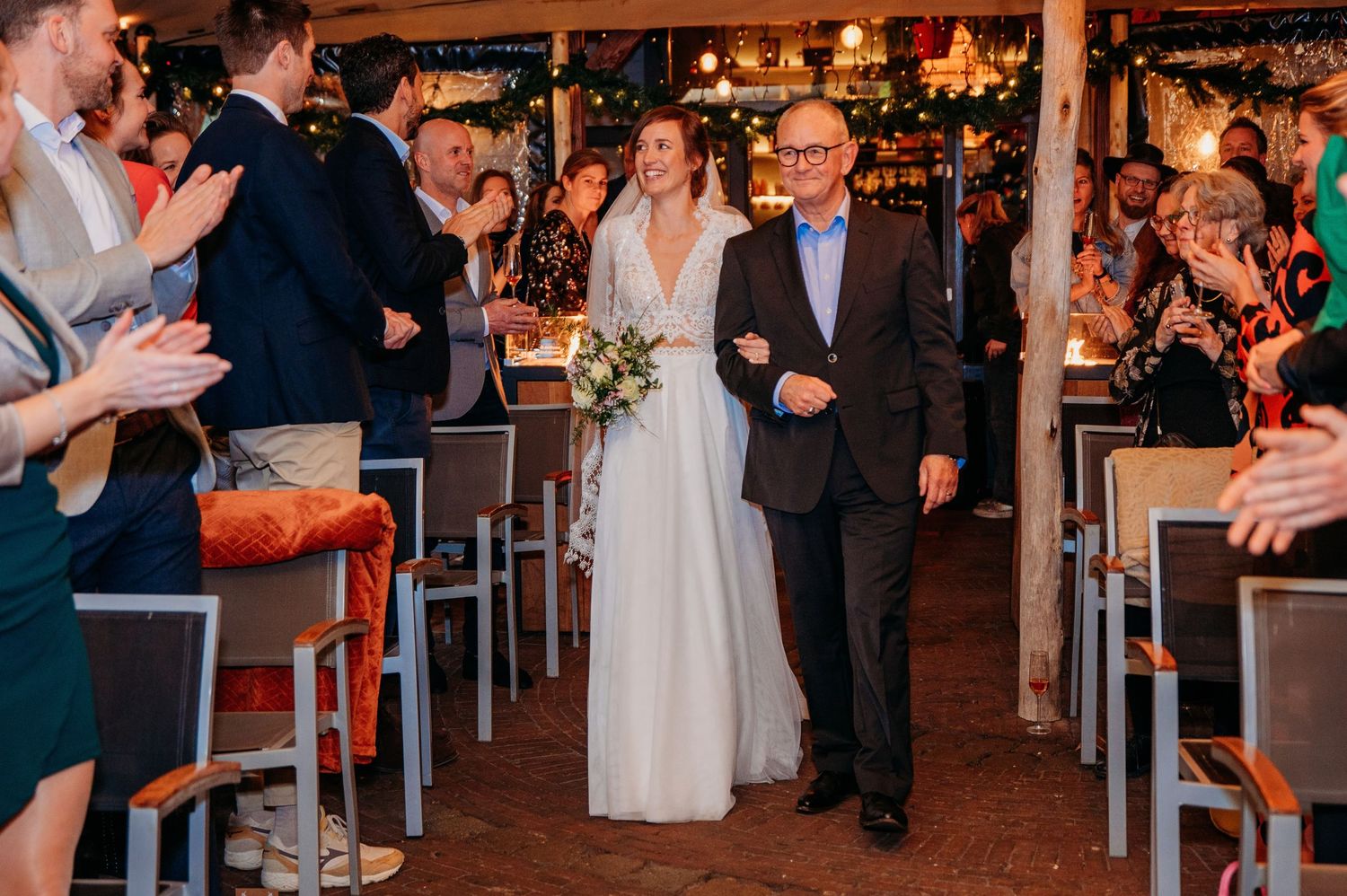 Bruiloftsgasten dansen in warm verlichte zaal, spontane bruidsfotografie bij Boscafé Oisterwijk, Brabant.