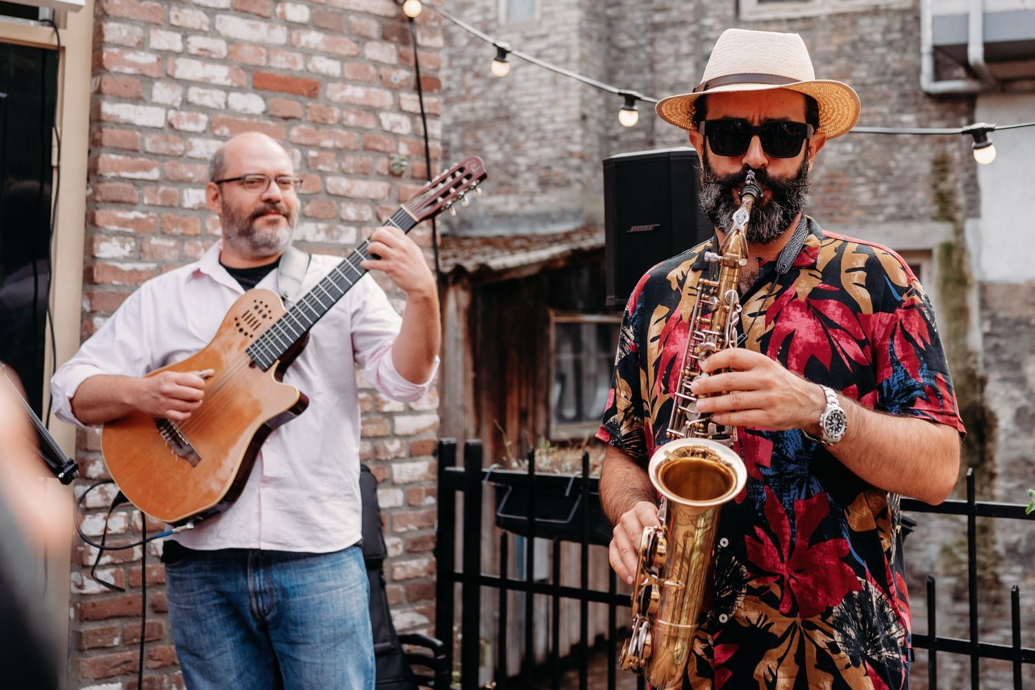 Muzikanten spelen saxofoon en gitaar in buitenruimte met bakstenen binnenplaats, eventfotografie Noordbrabants Museum Den Bosch, Brabant.