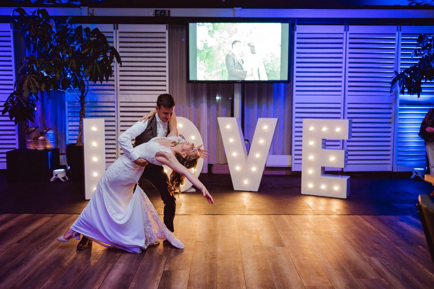 Dansvloer bij bruiloft met LOVE letters en blauw licht, bruidsfotografie IJM IJzereman Vught, Brabant.