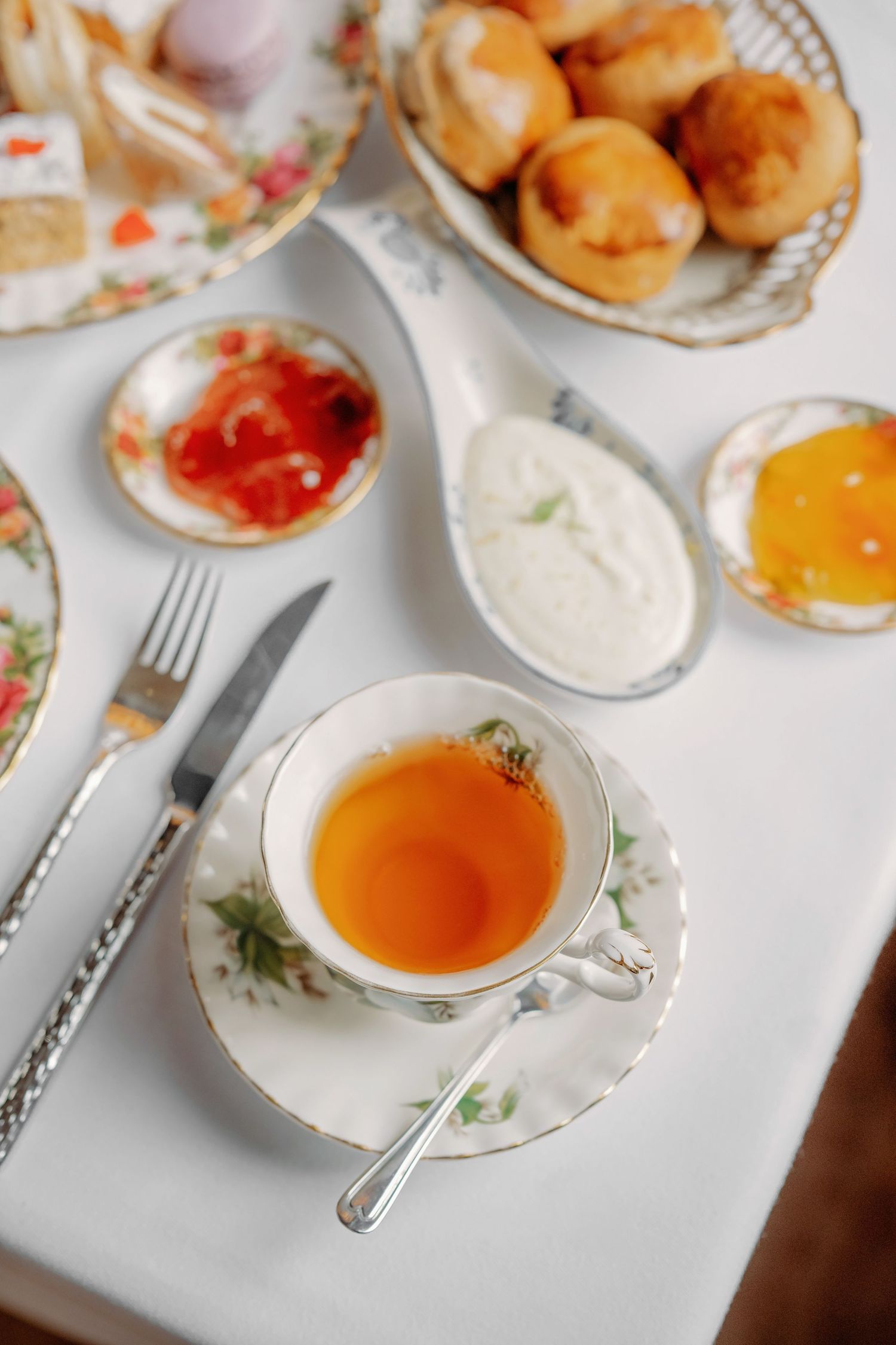 Elegante afternoon tea met scones en honing op bloemen servies, foodfotografie Brabant